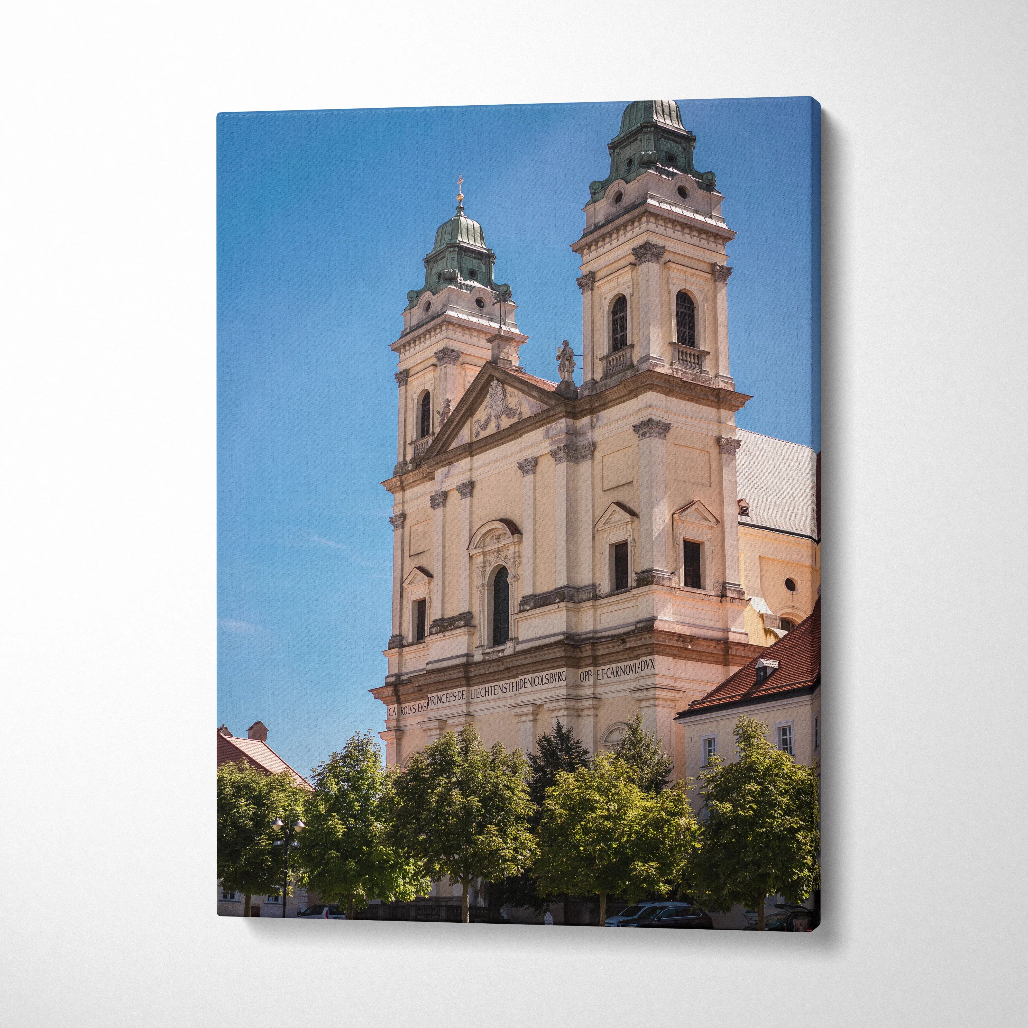 Vertical canvas wall art featuring a historic beige building with twin towers against a clear blue sky.