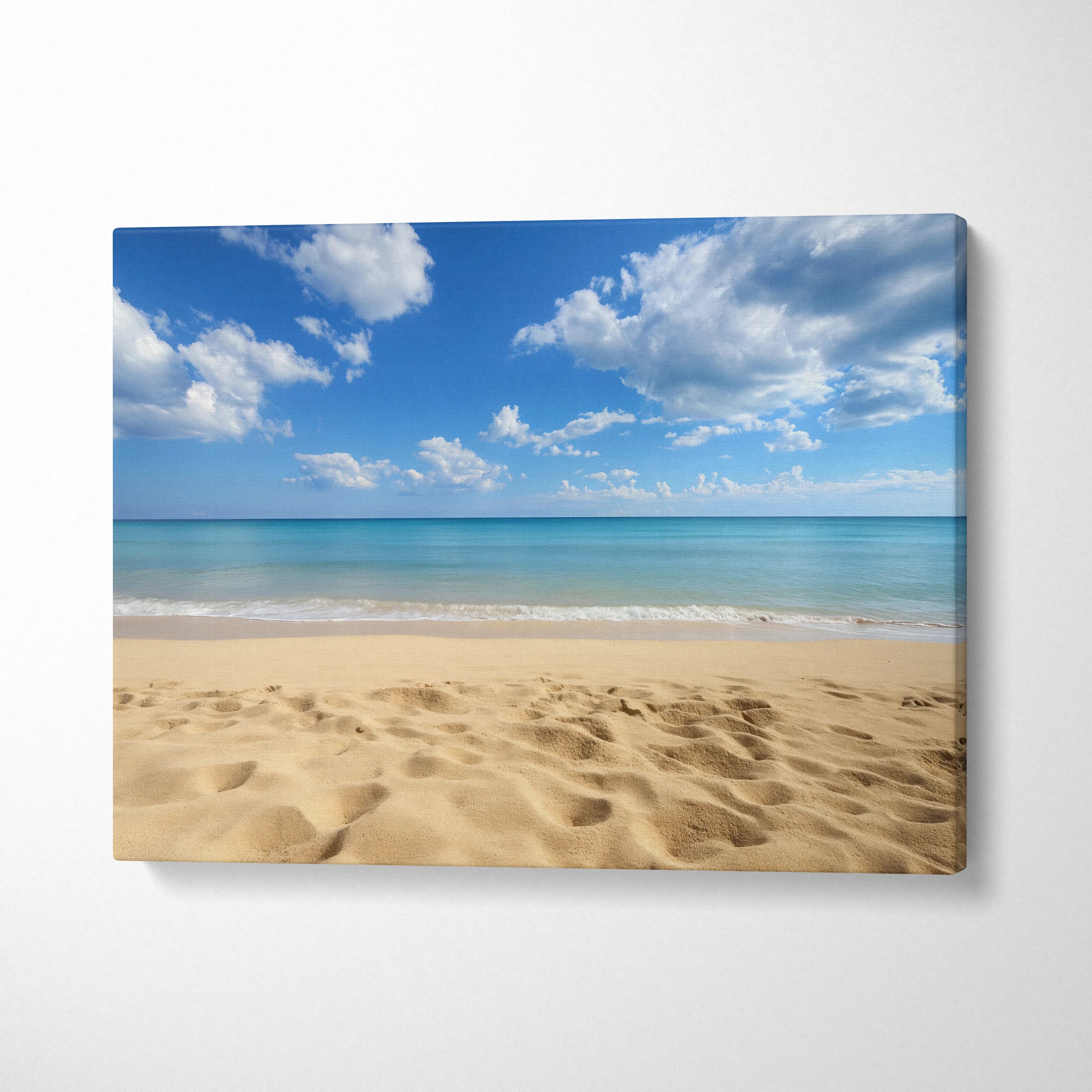 Canvas wall art featuring a sandy beach with gentle ocean waves and a bright blue sky with scattered clouds.