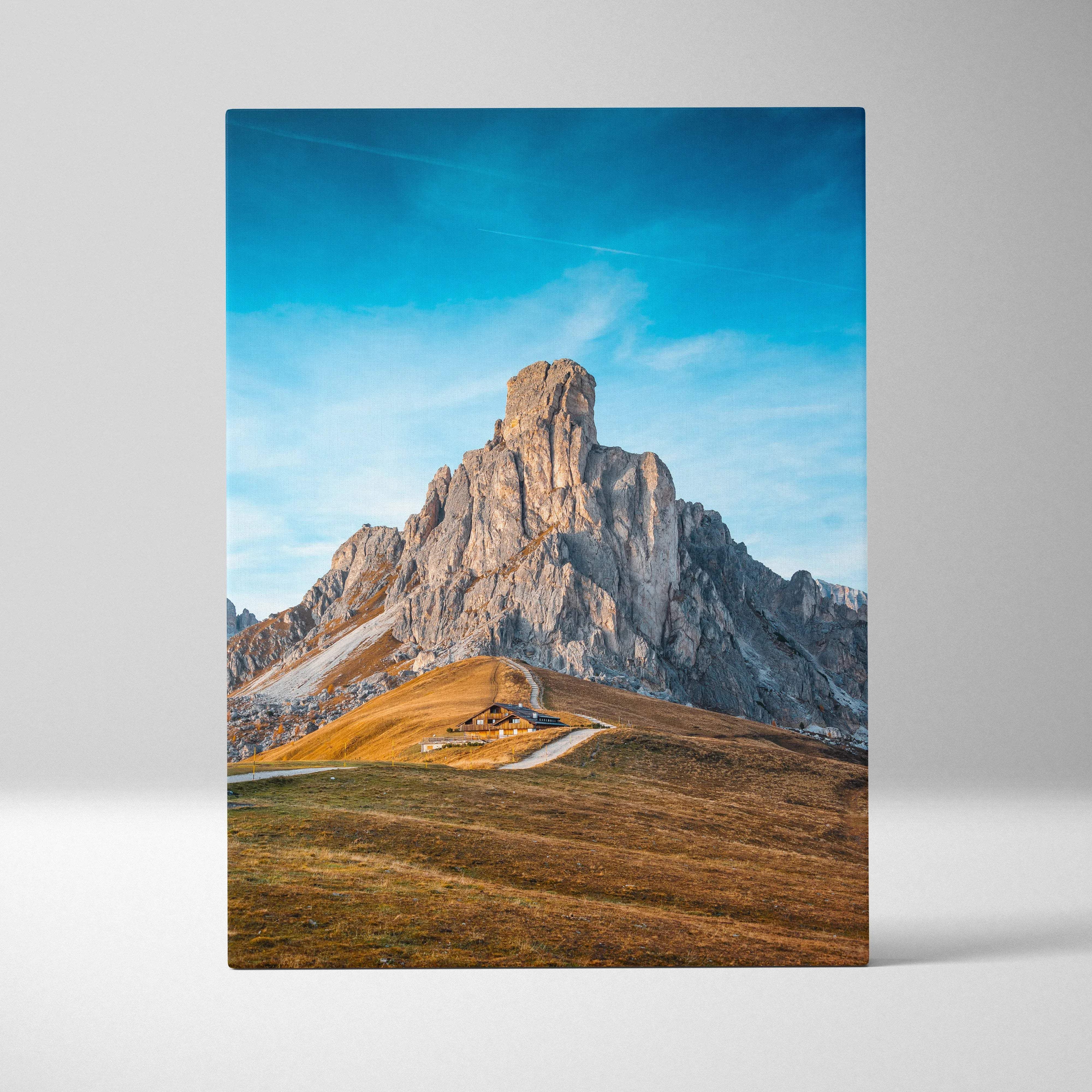 Canvas print of rugged Ra Gusela Peak over Giau Pass under blue sky