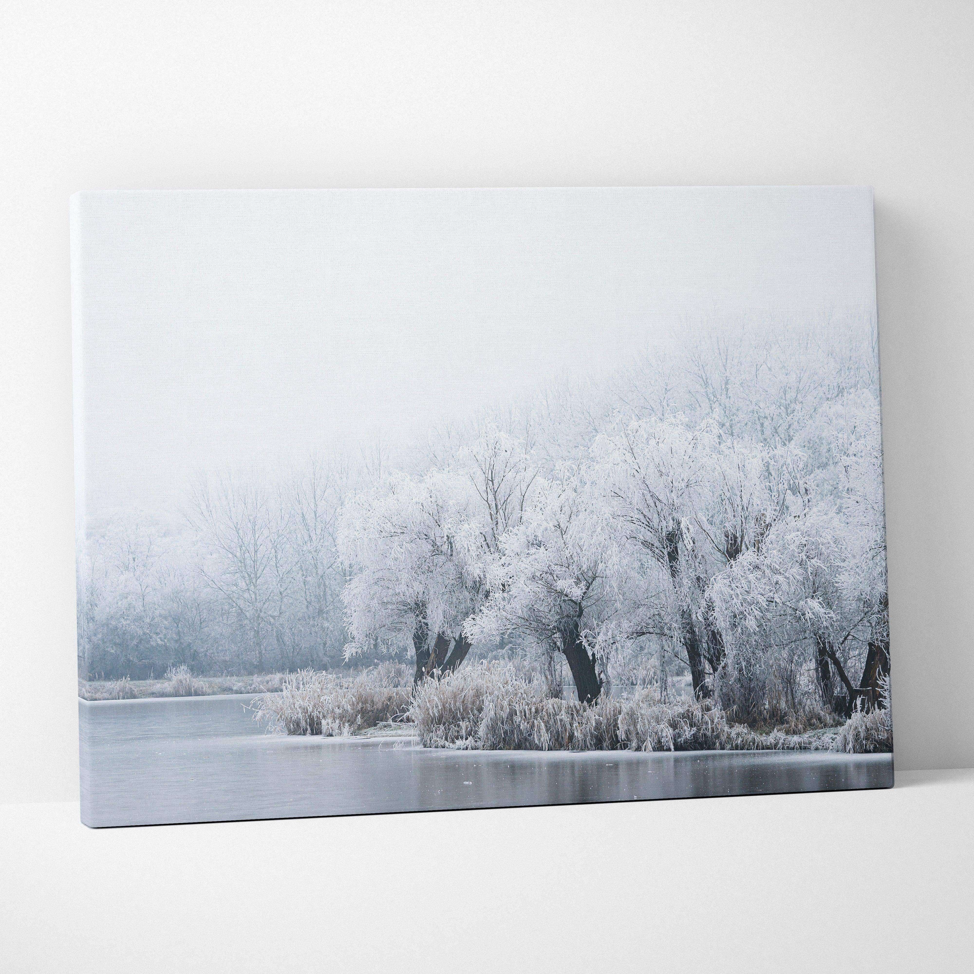 Framed canvas print of a winter landscape with frost-covered trees and a misty river in soft blues and grays
