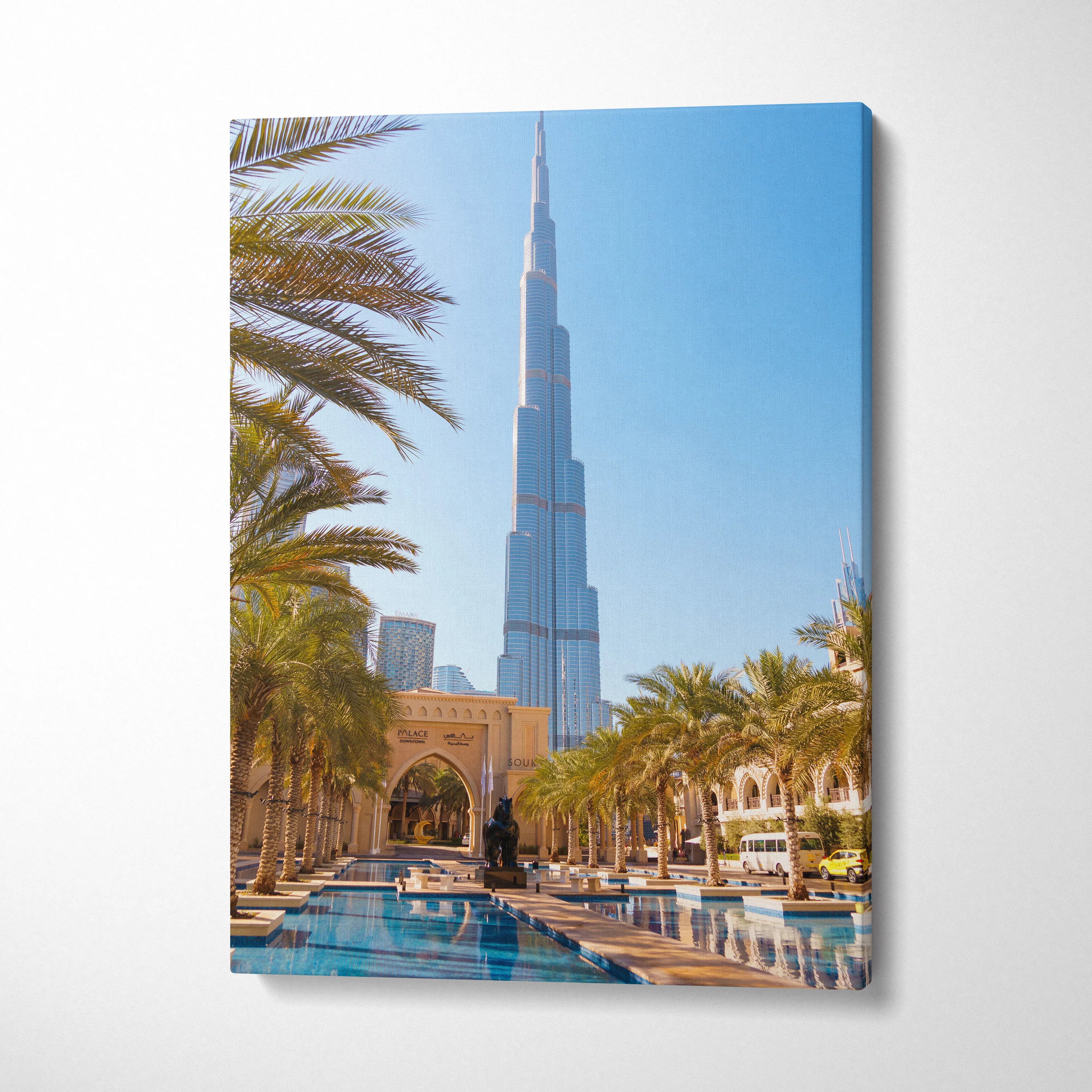 Vertical canvas art featuring the Burj Khalifa skyscraper with palm trees and a reflective pool, modern wall art.