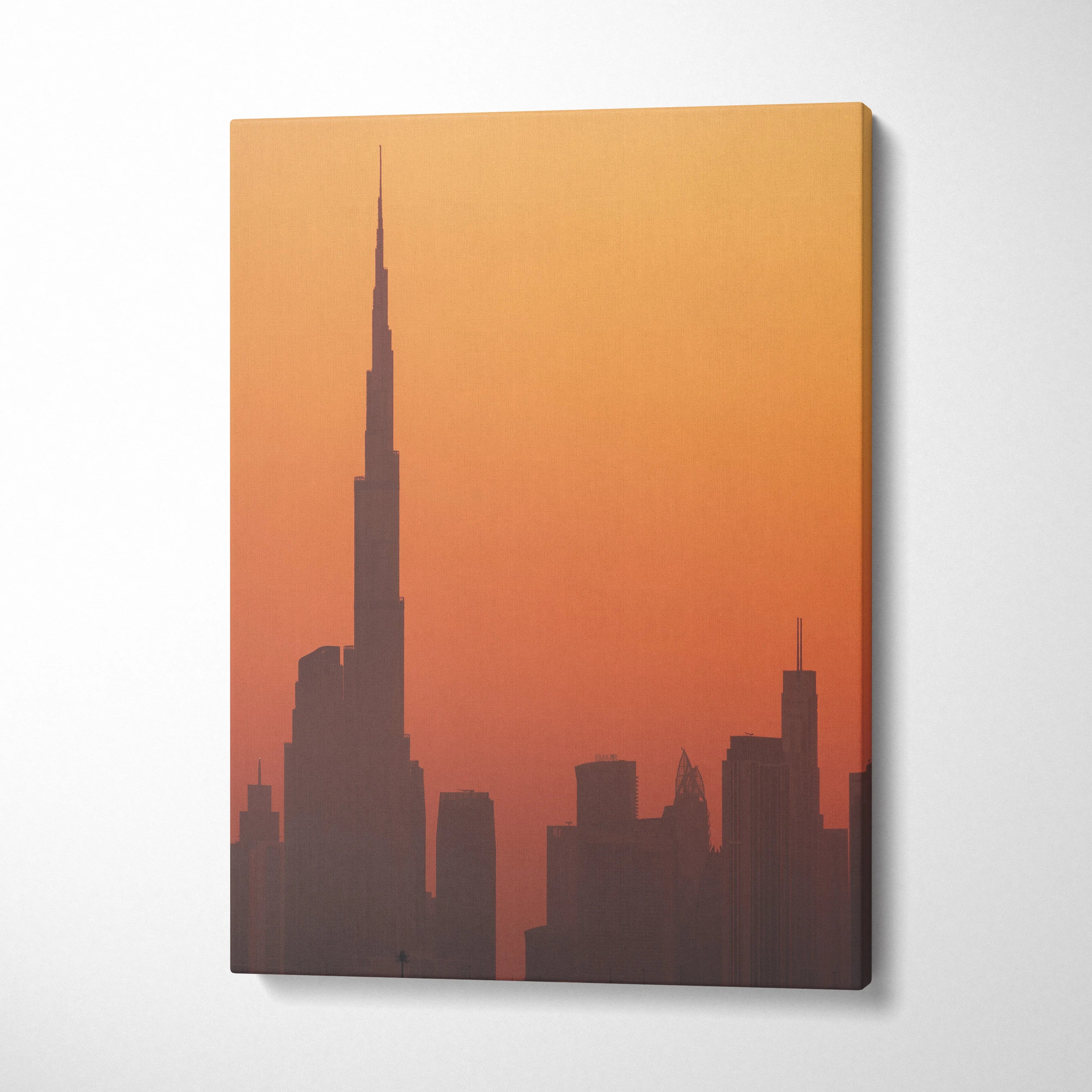 Canvas wall art featuring a silhouette of a city skyline at sunset with orange and red tones.
