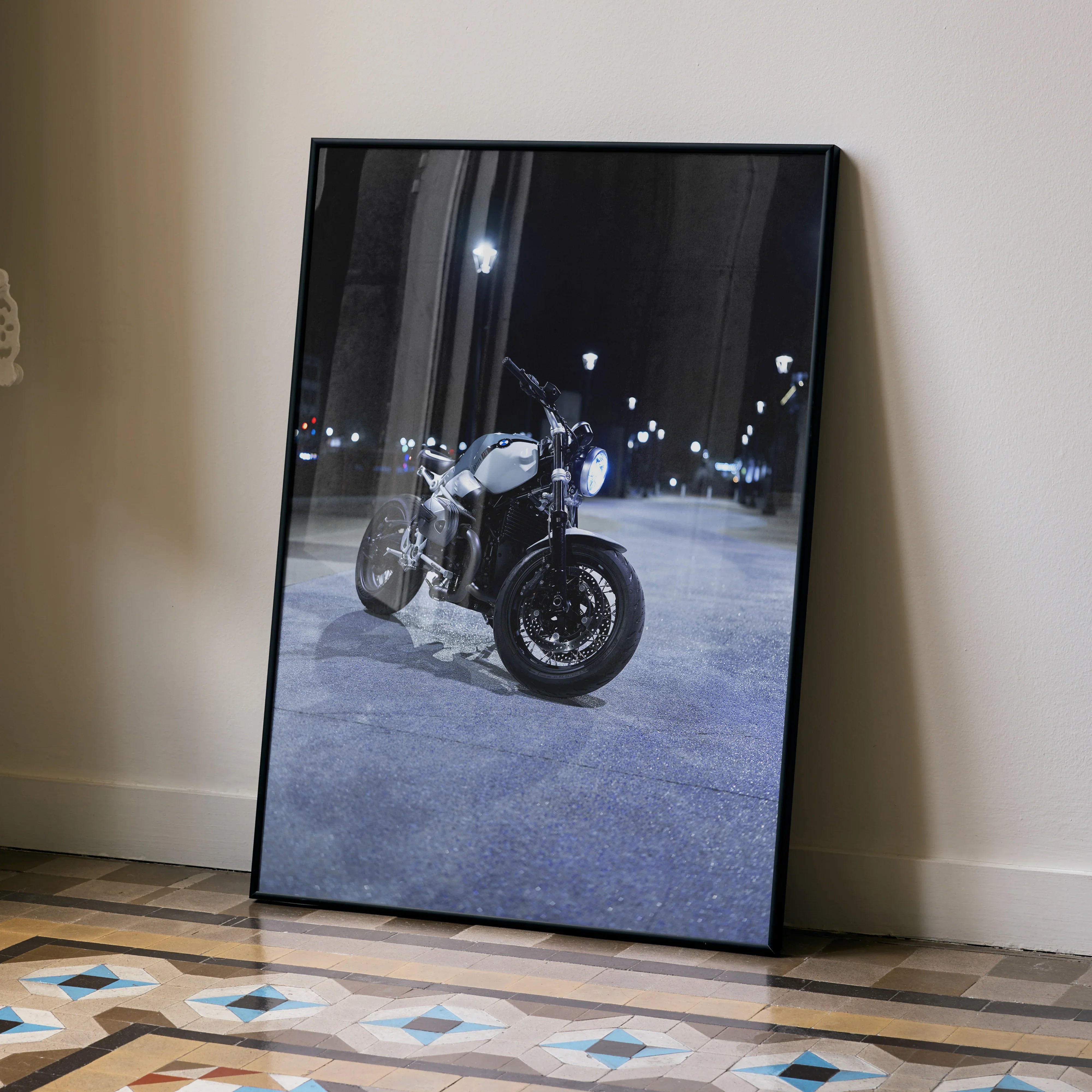 BMW R Nine T motorcycle poster in black frame leaning on wall, night street scene wall art.