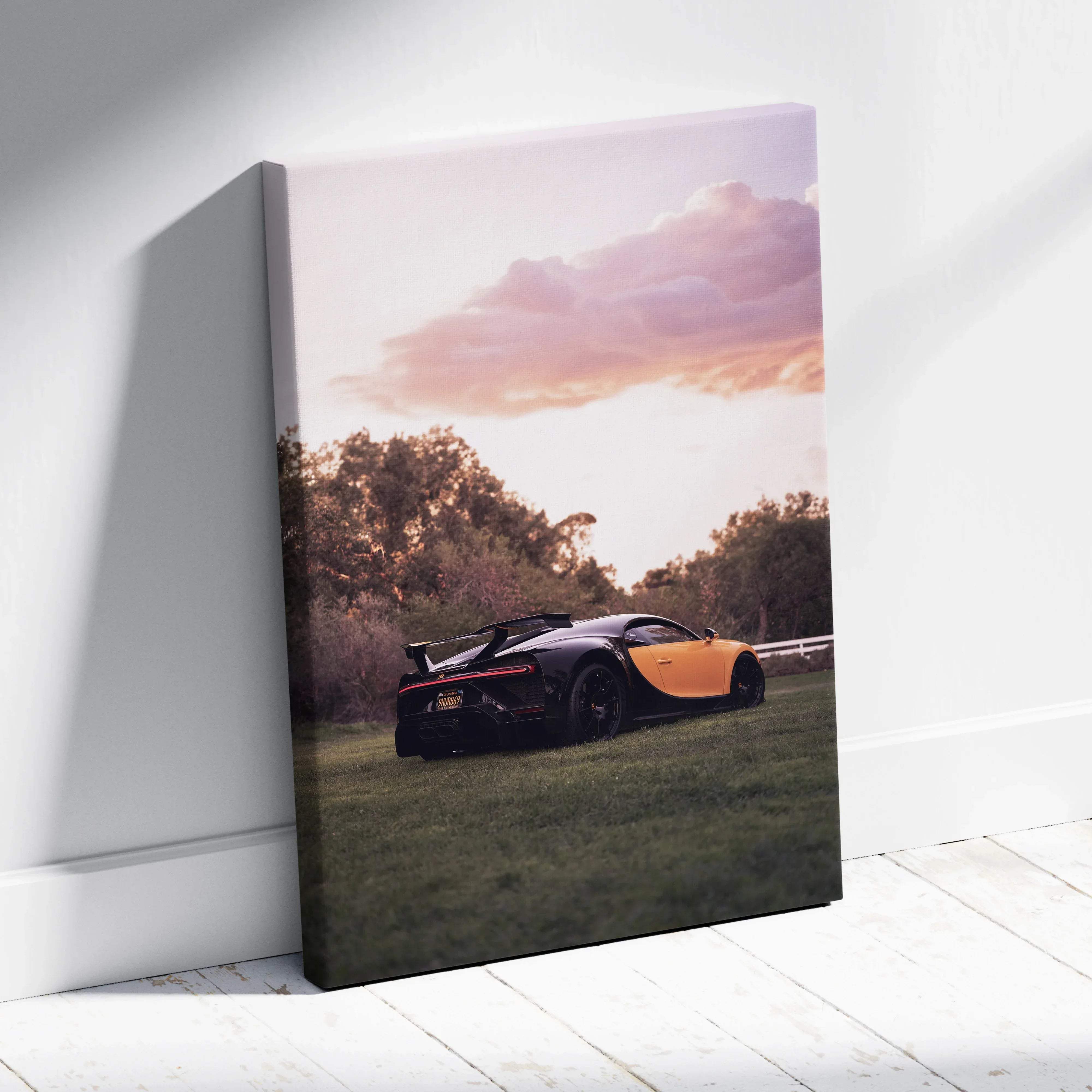 A vibrant orange and black Bugatti Chiron canvas wall art print showcasing sleek design and warm sunset tones