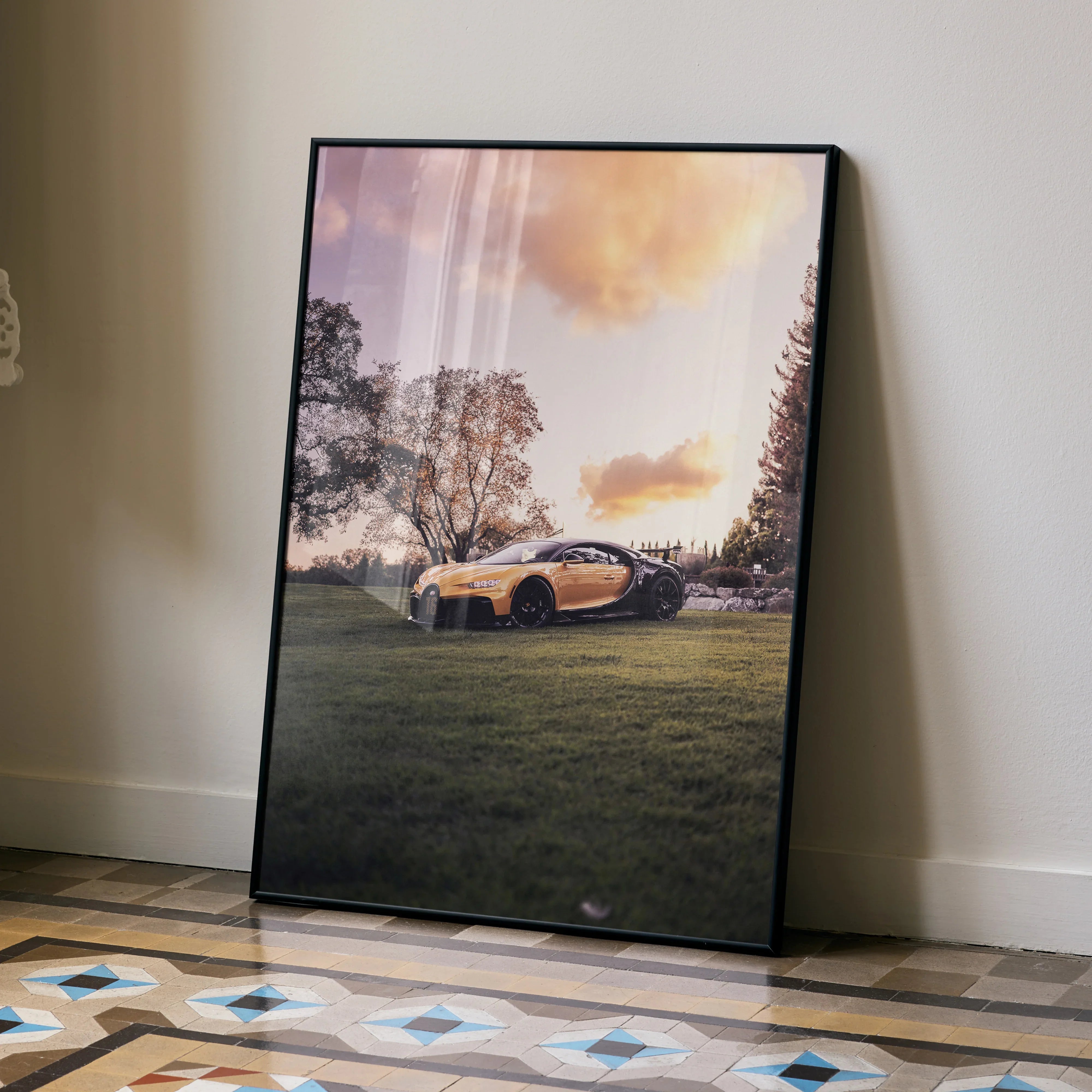 Bugatti Chiron Pur Sport parked on grass at sunset wall art poster in black frame.