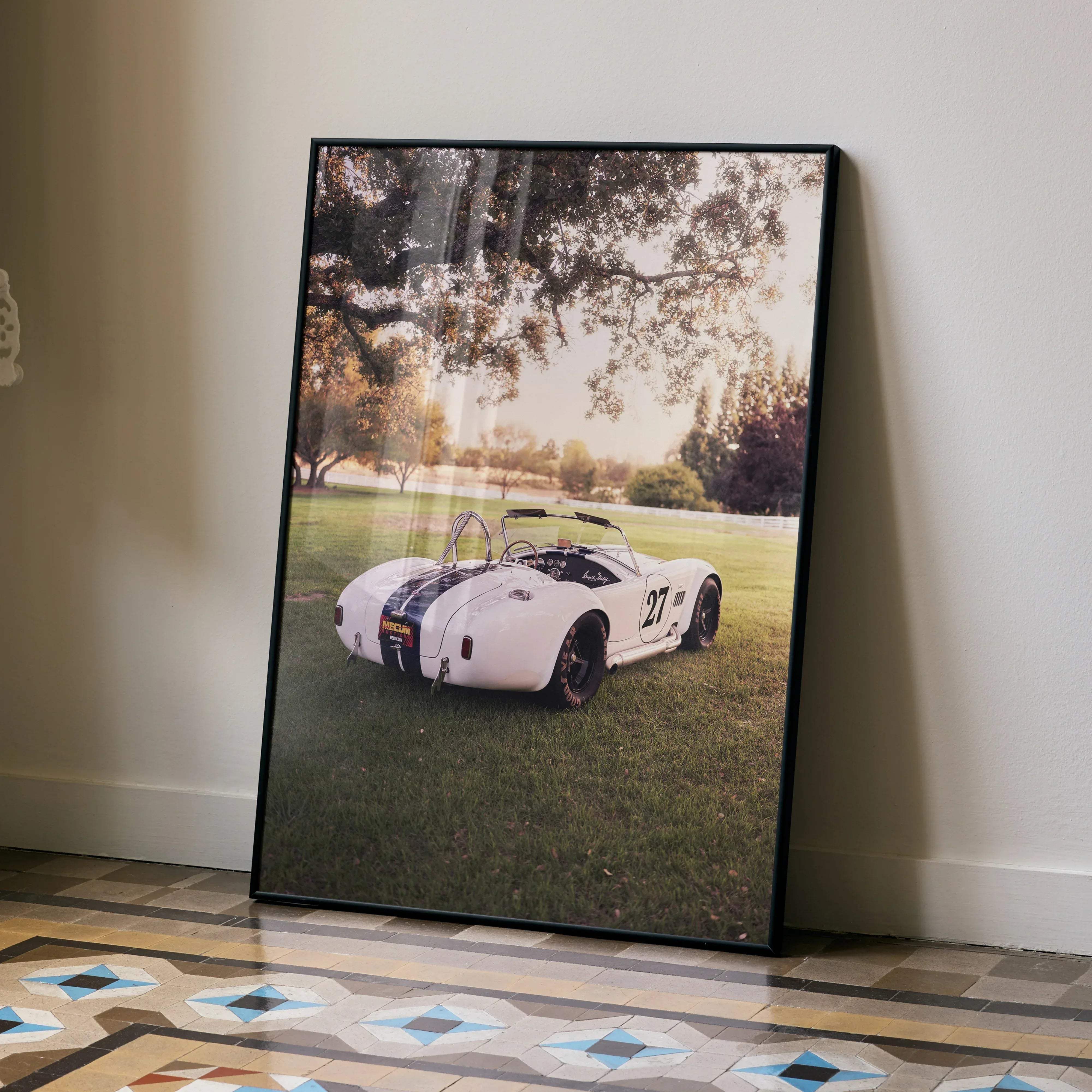 A framed high resolution Shelby Cobra art poster of a white vintage race car with black stripes and number 27
