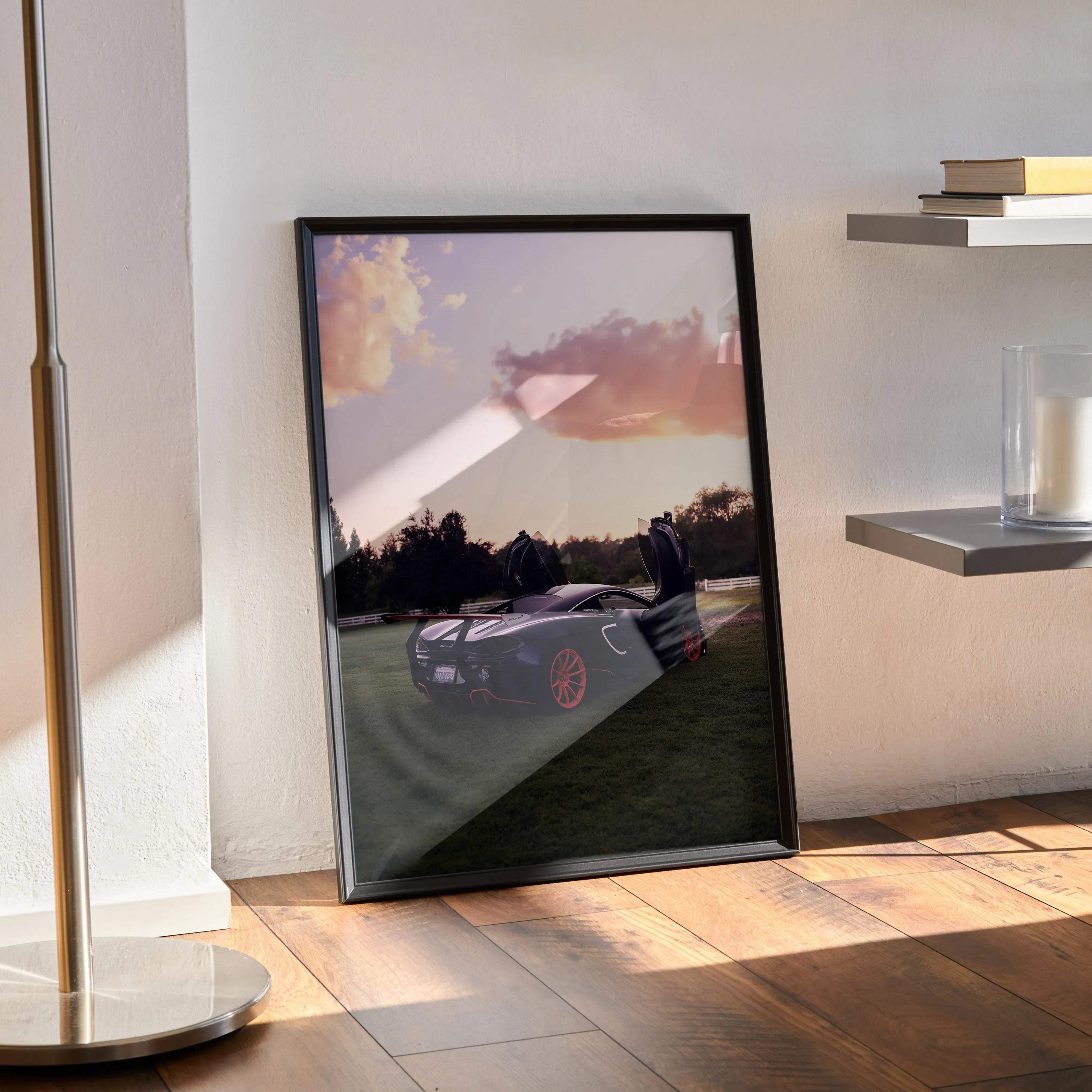 Black-framed McLaren 570s automotive art poster featuring a sleek dark purple sports car with red wheels at sunset