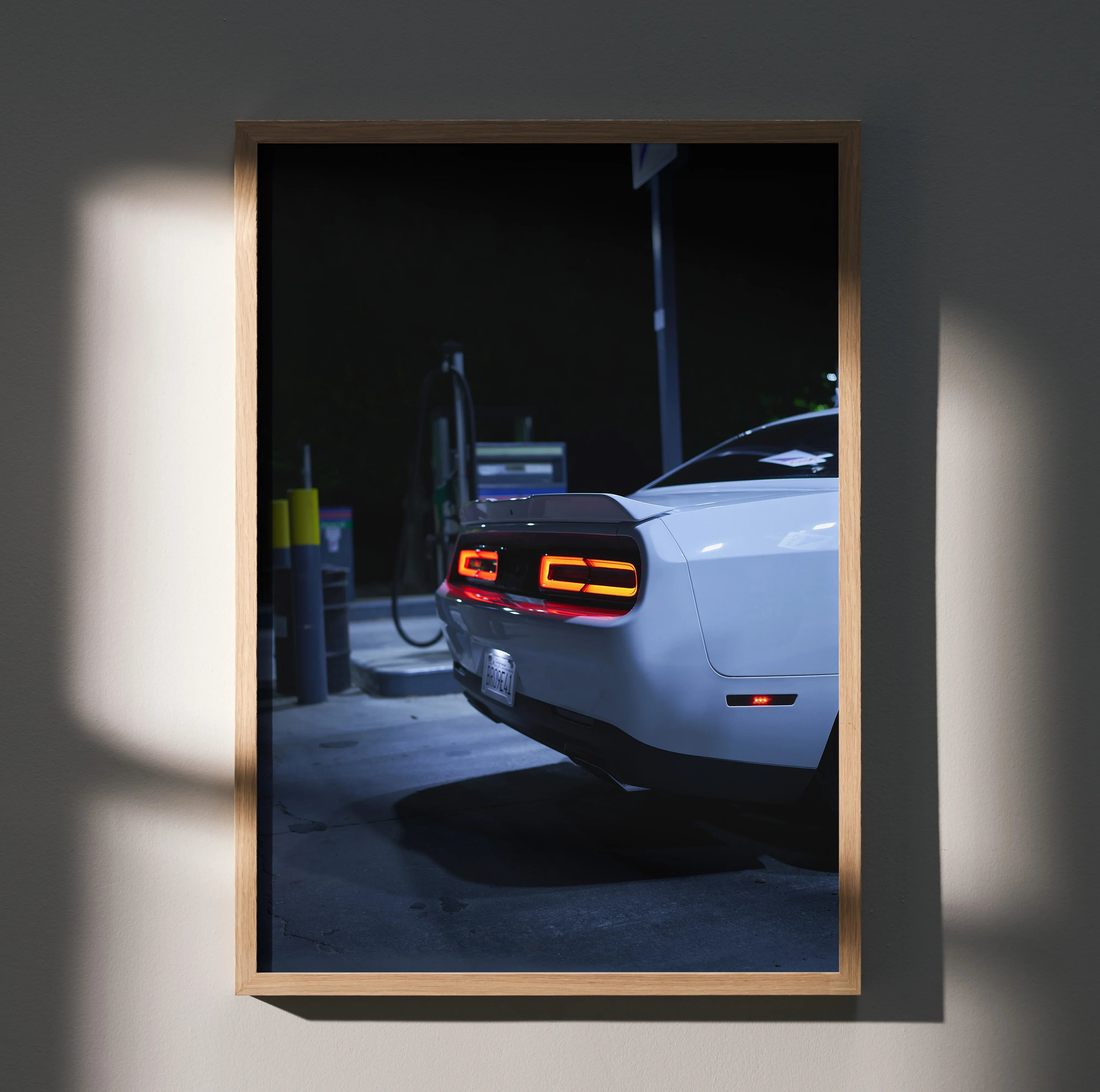 Dodge Challenger rear view with illuminated taillights at night poster wall art in wooden frame.
