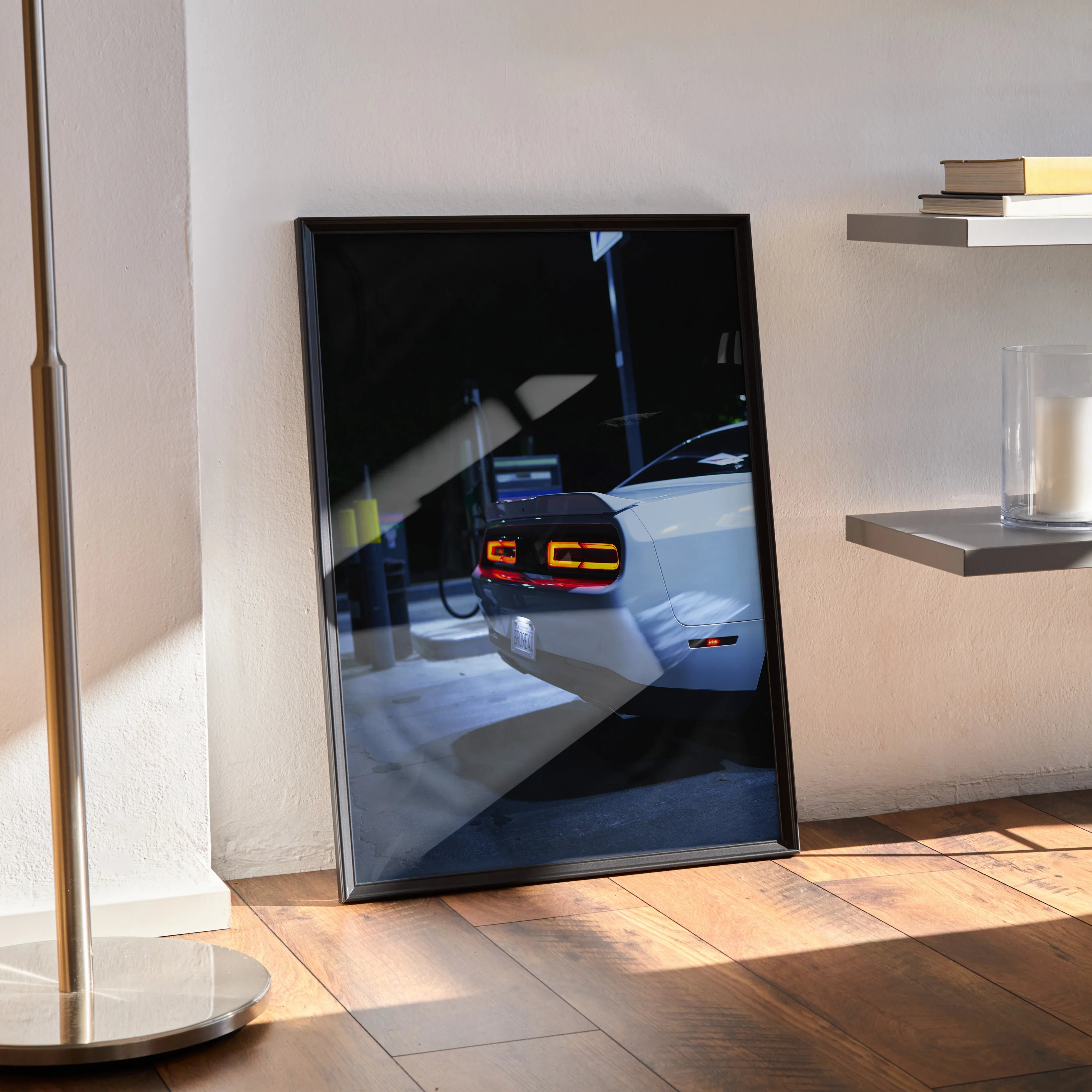 Dodge Challenger rear light close-up poster in black frame leaning on wall, automotive wall art.