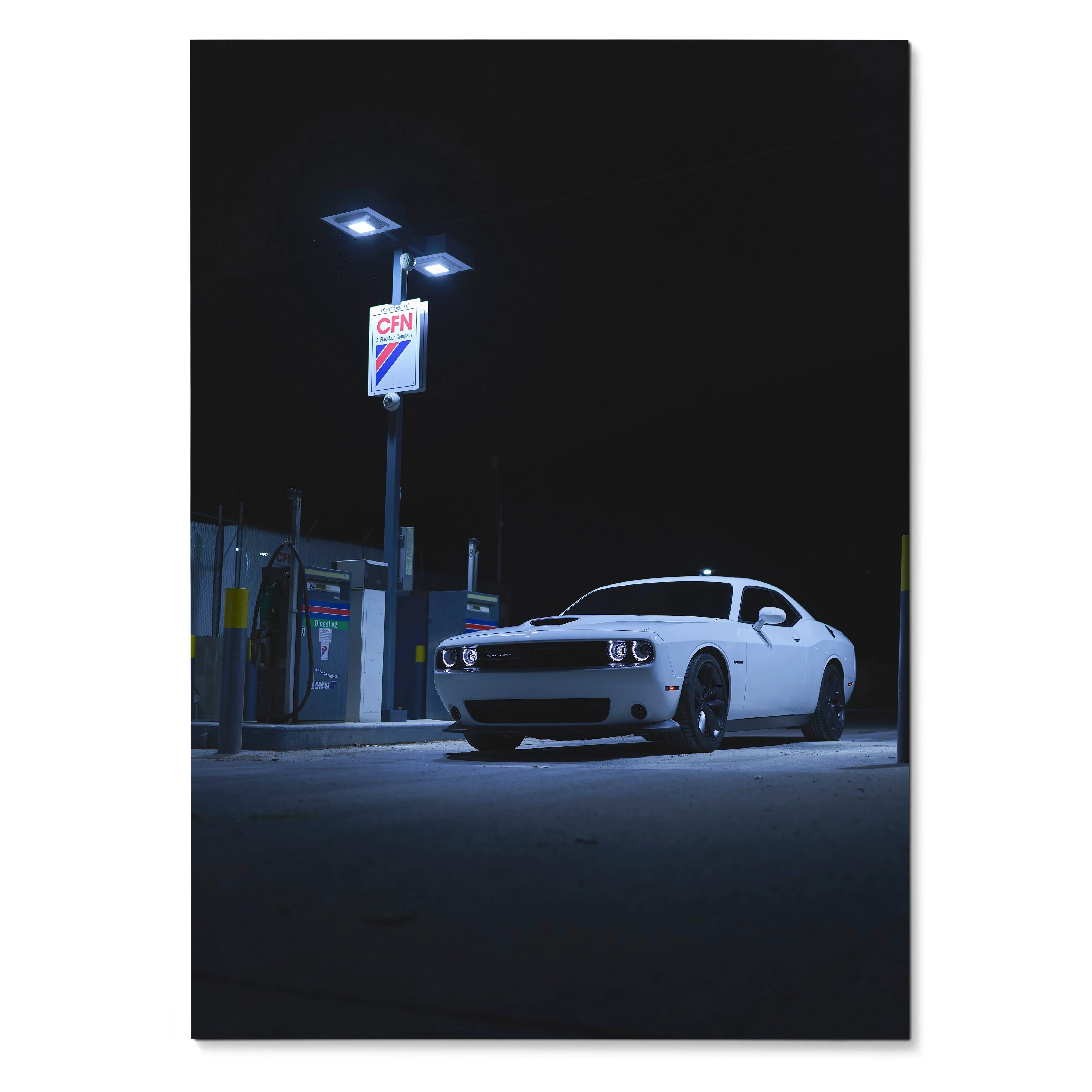 White Dodge Challenger parked under bright streetlights at night poster wall art.