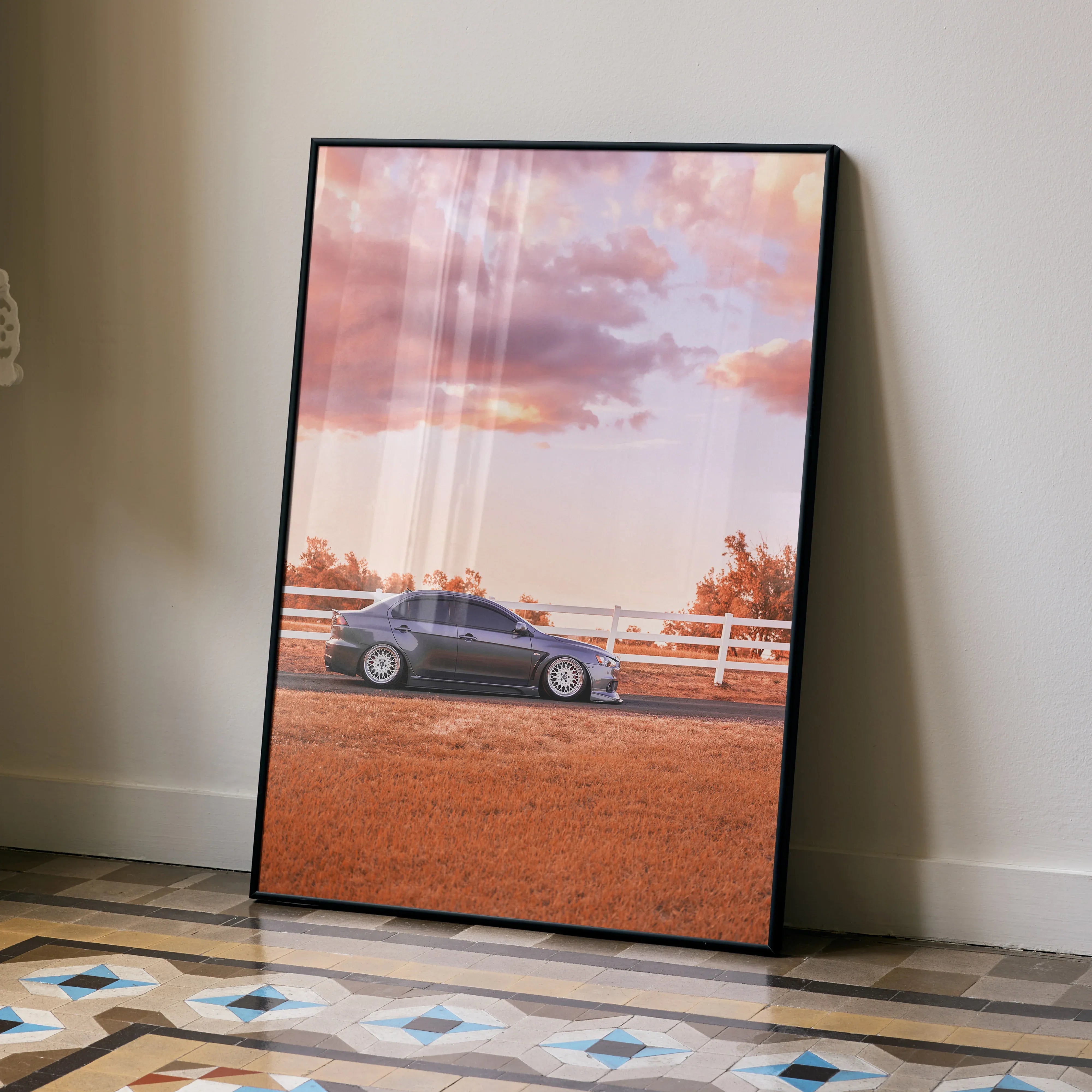 Mitsubishi Evo 10 poster wall art with sunset sky and rural fence background in black frame.