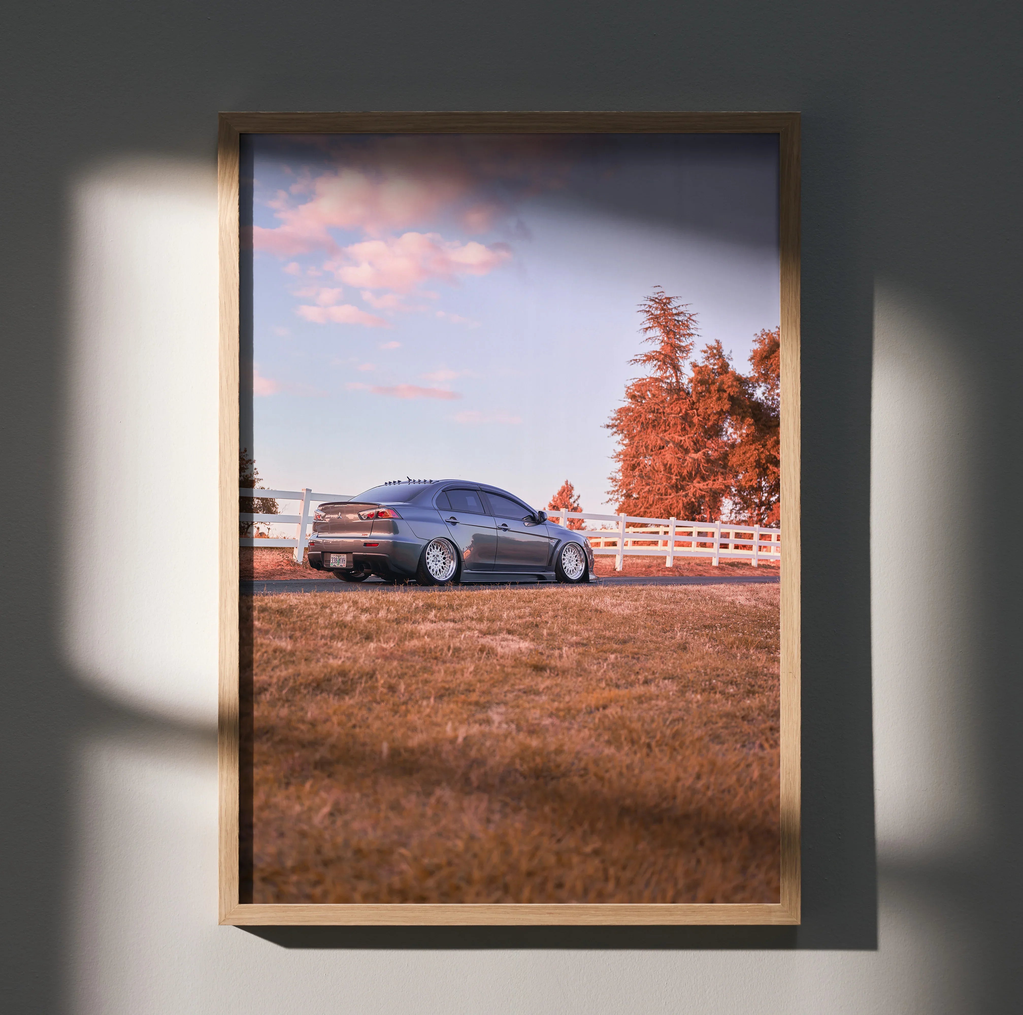 Mitsubishi Evo 10 poster showing car on grassy field under soft sunset sky, framed wall art.
