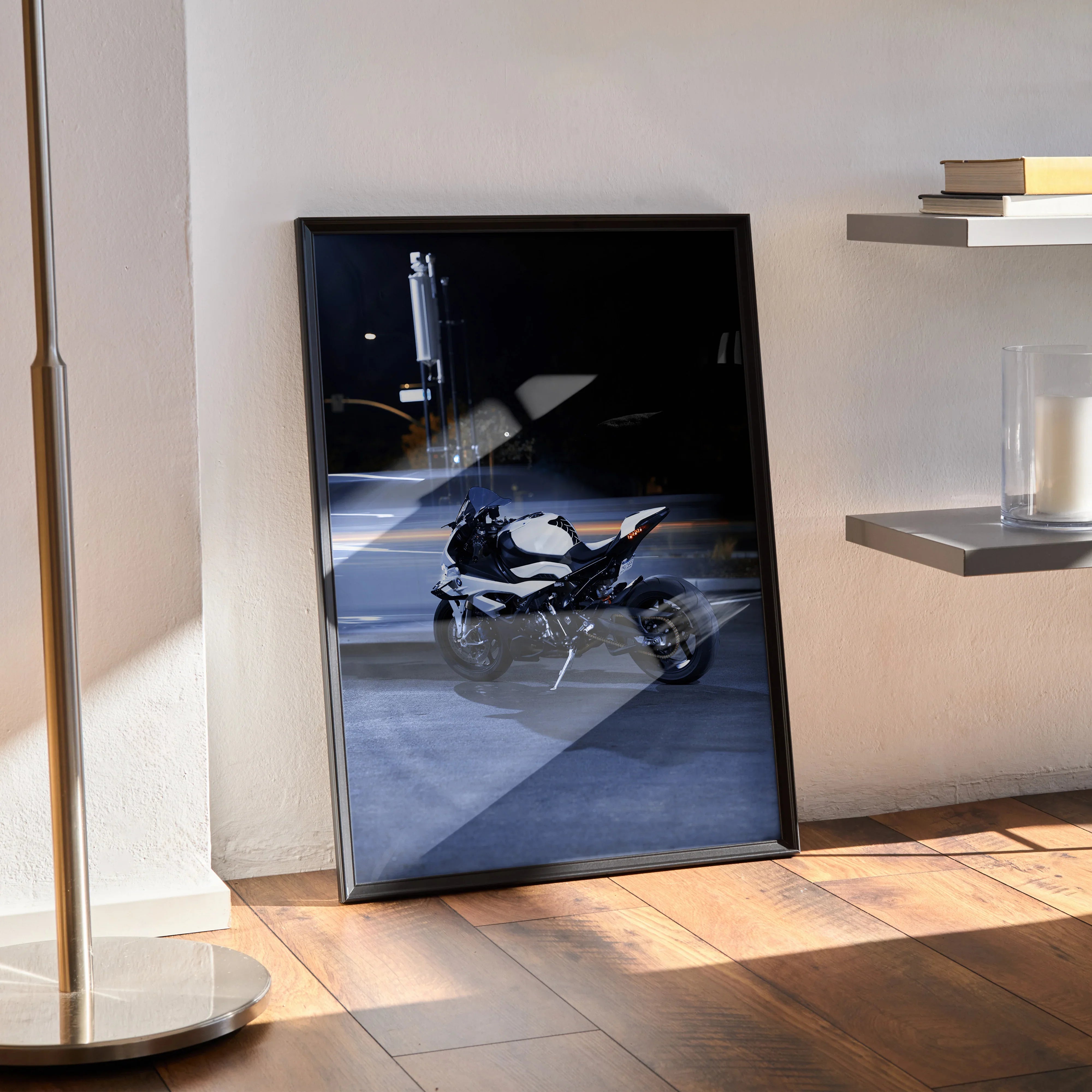BMW S1000RR motorcycle poster wall art in black frame leaning on floor in modern room.