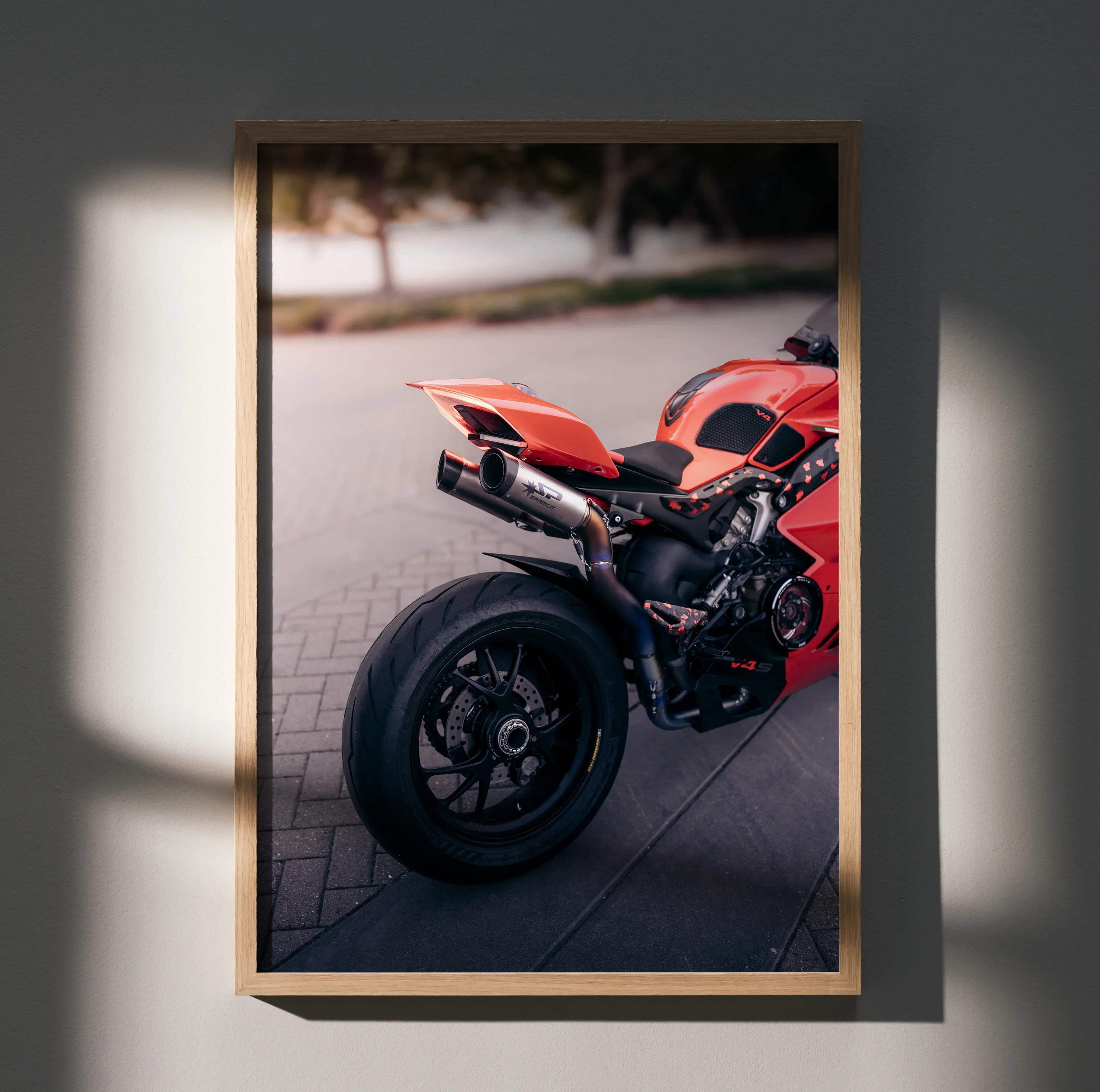 Framed photograph of a red ducati panigale v4s motorcycle with black tires and chrome exhaust in a poster format