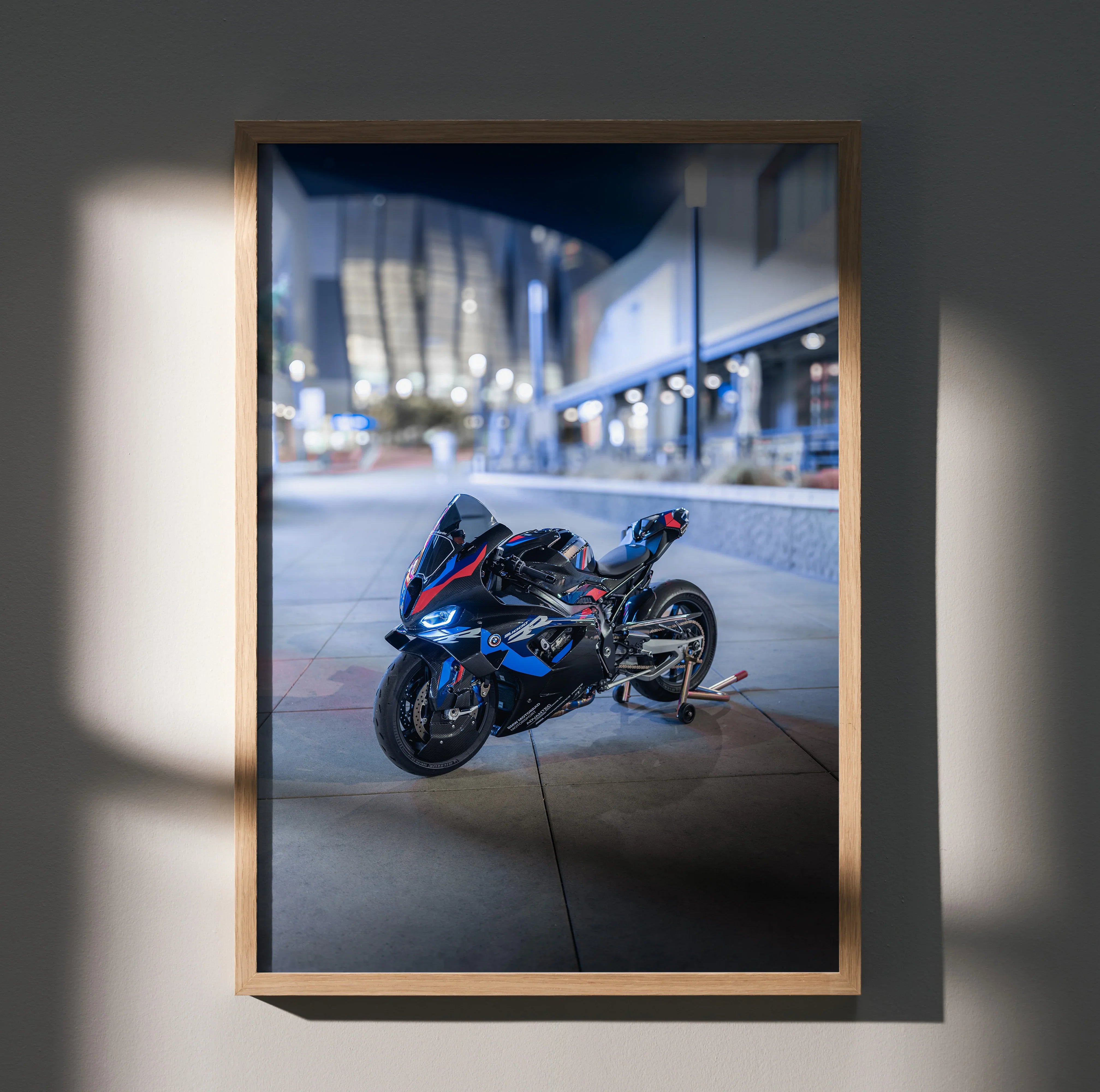 Black BMW M1000RR motorcycle poster with blue and red accents, urban night scene wall art in wooden frame.