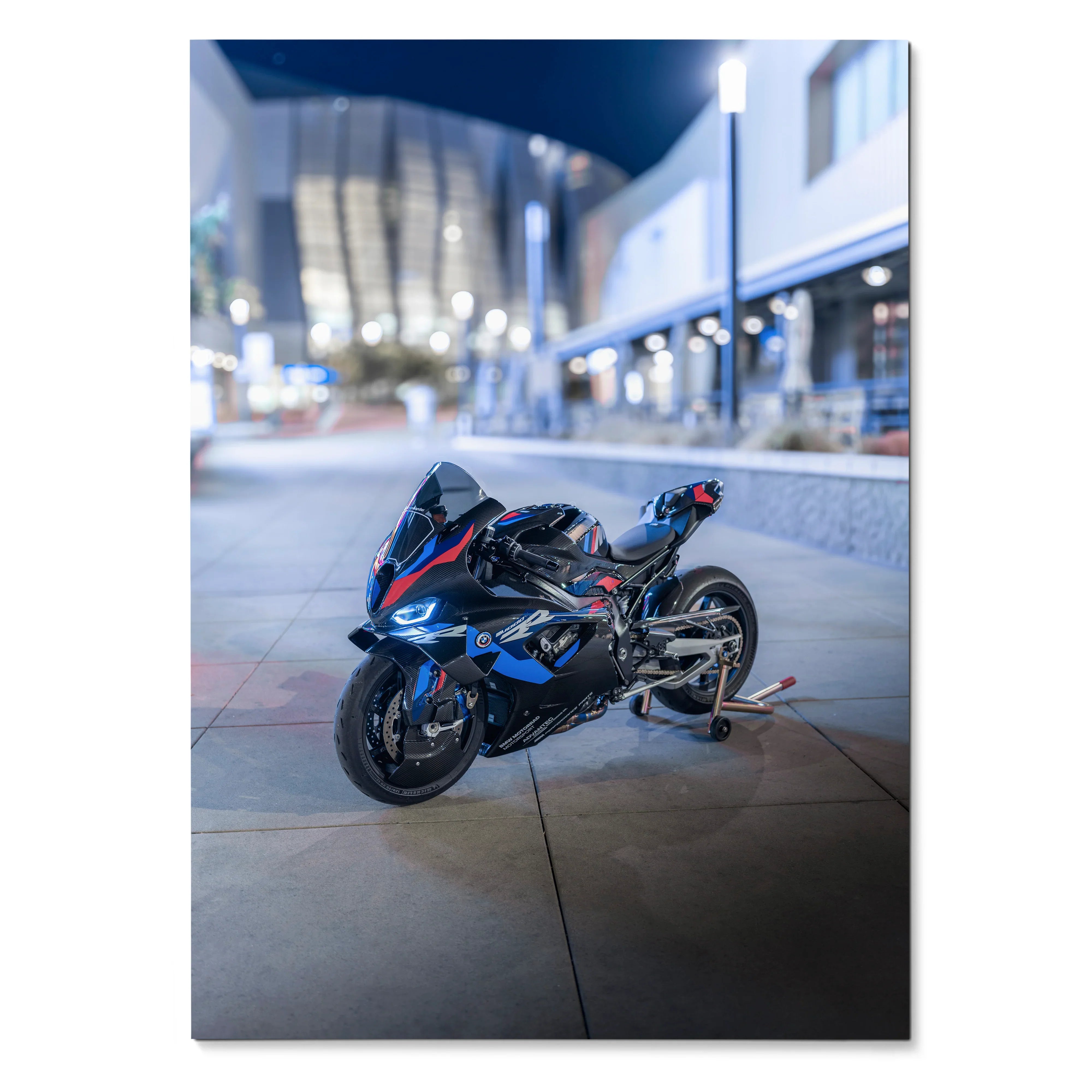 BMW M1000RR motorcycle wall art poster featuring sleek black and blue sportbike on urban pavement at night.
