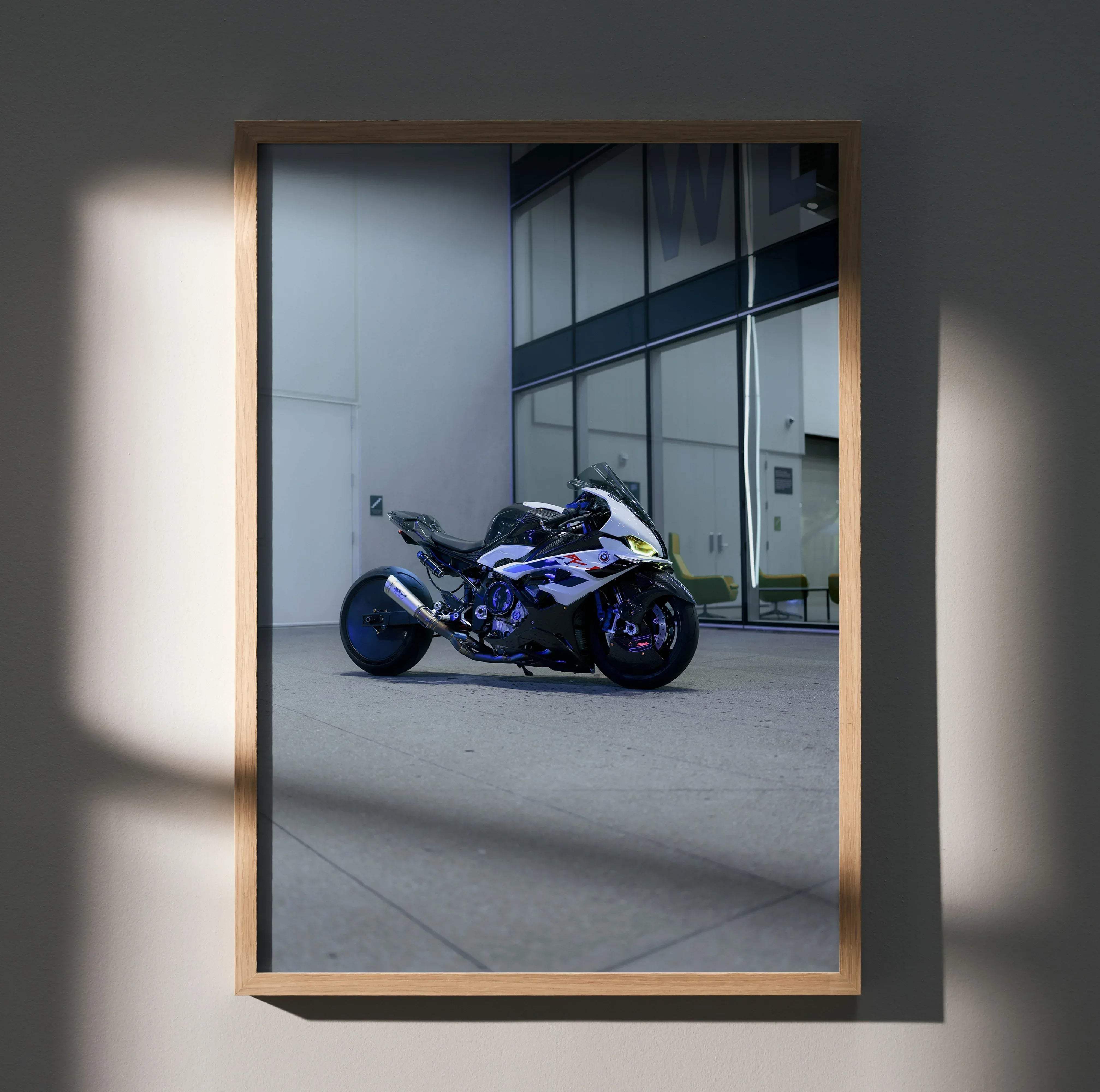 A framed photograph of a white and blue Suzuki sport motorcycle with purple accents in a minimalist setting