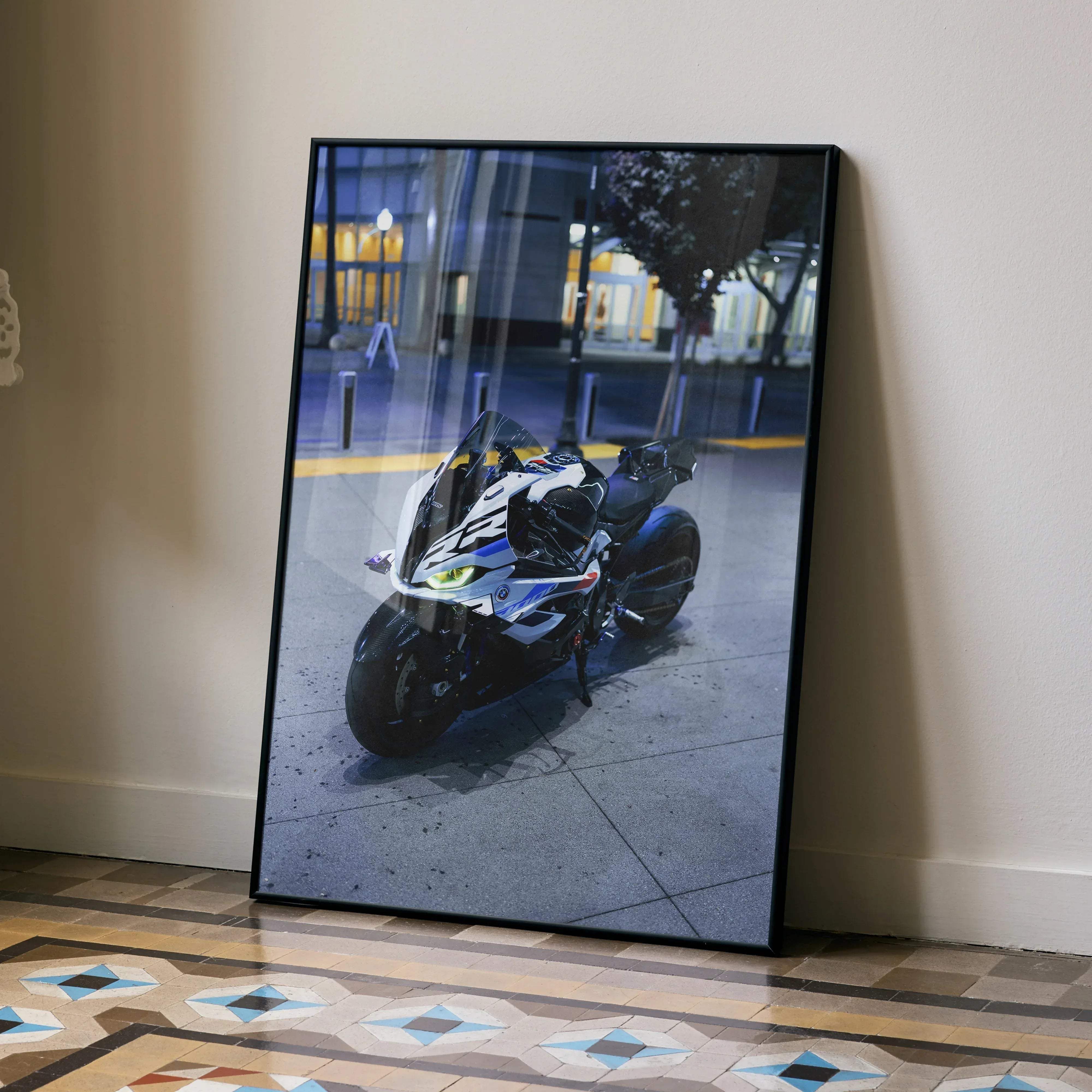 Black-framed photograph of a white and blue bmw s1000rr drag spec motorcycle parked on pavement at night