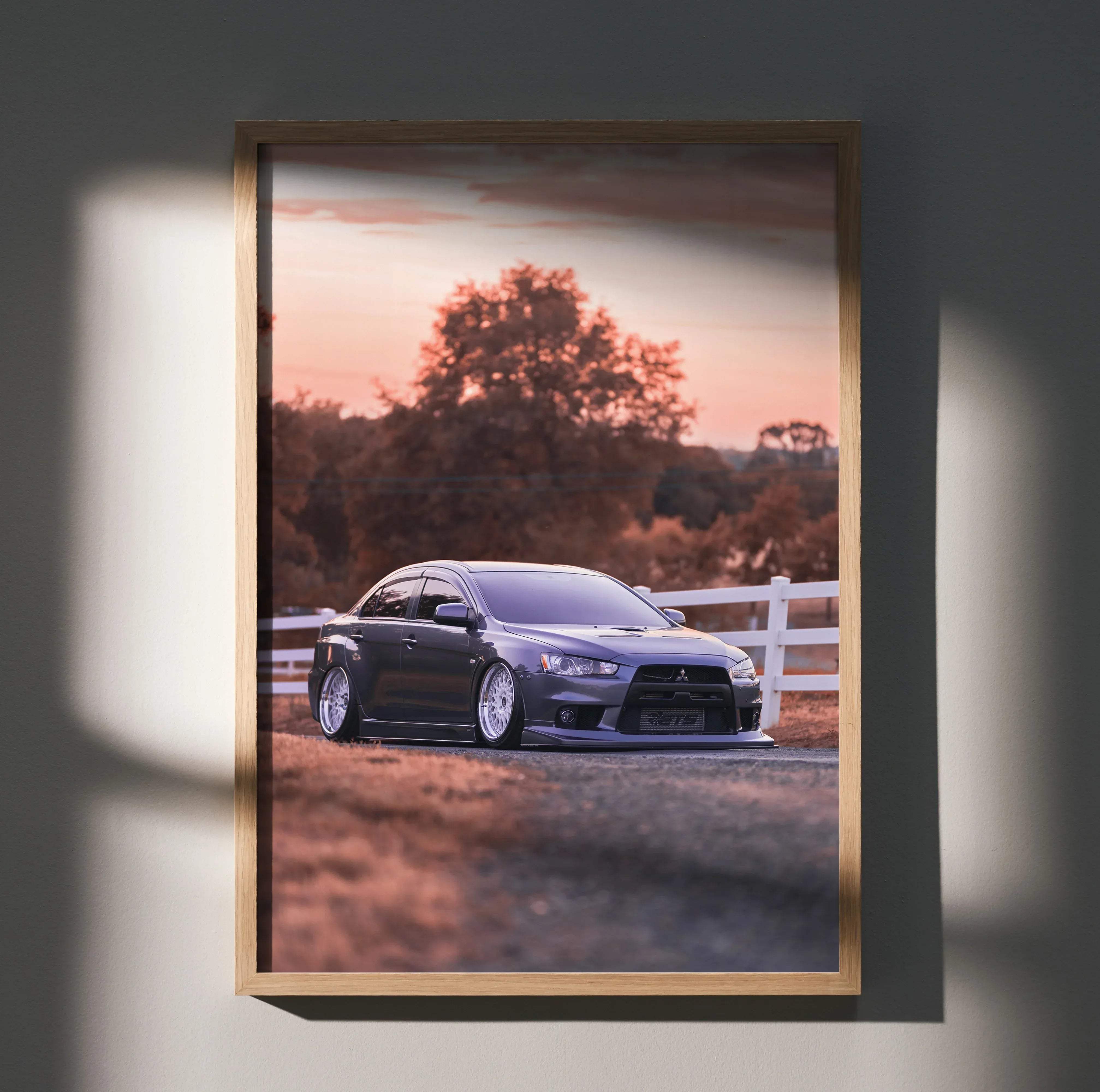 Dark gray mitsubishi evo 10 sports car poster in a light wood frame high resolution wall art print