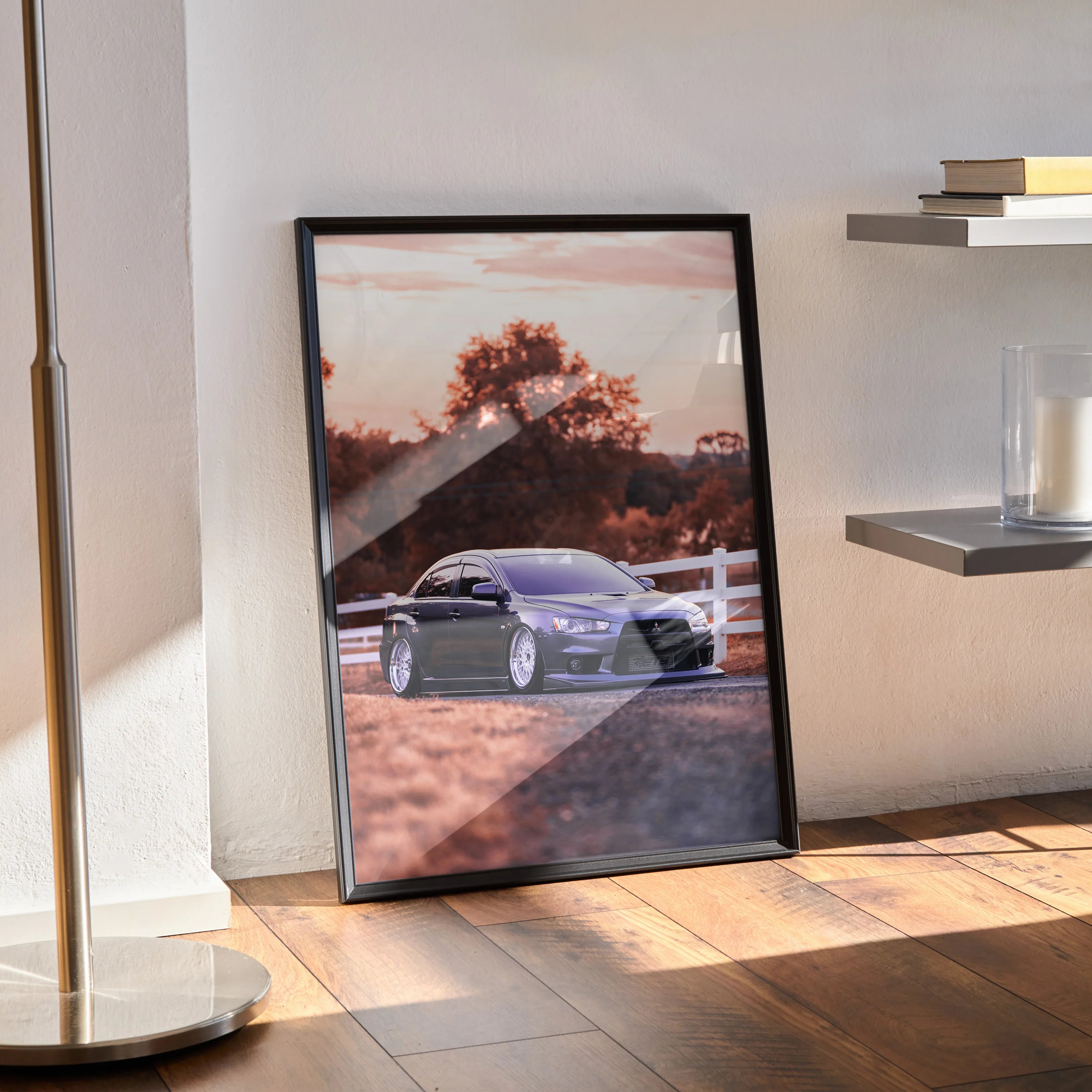 Mitsubishi Evo 10 poster wall art featuring a sleek silver car parked by a white fence at sunset with warm tones.