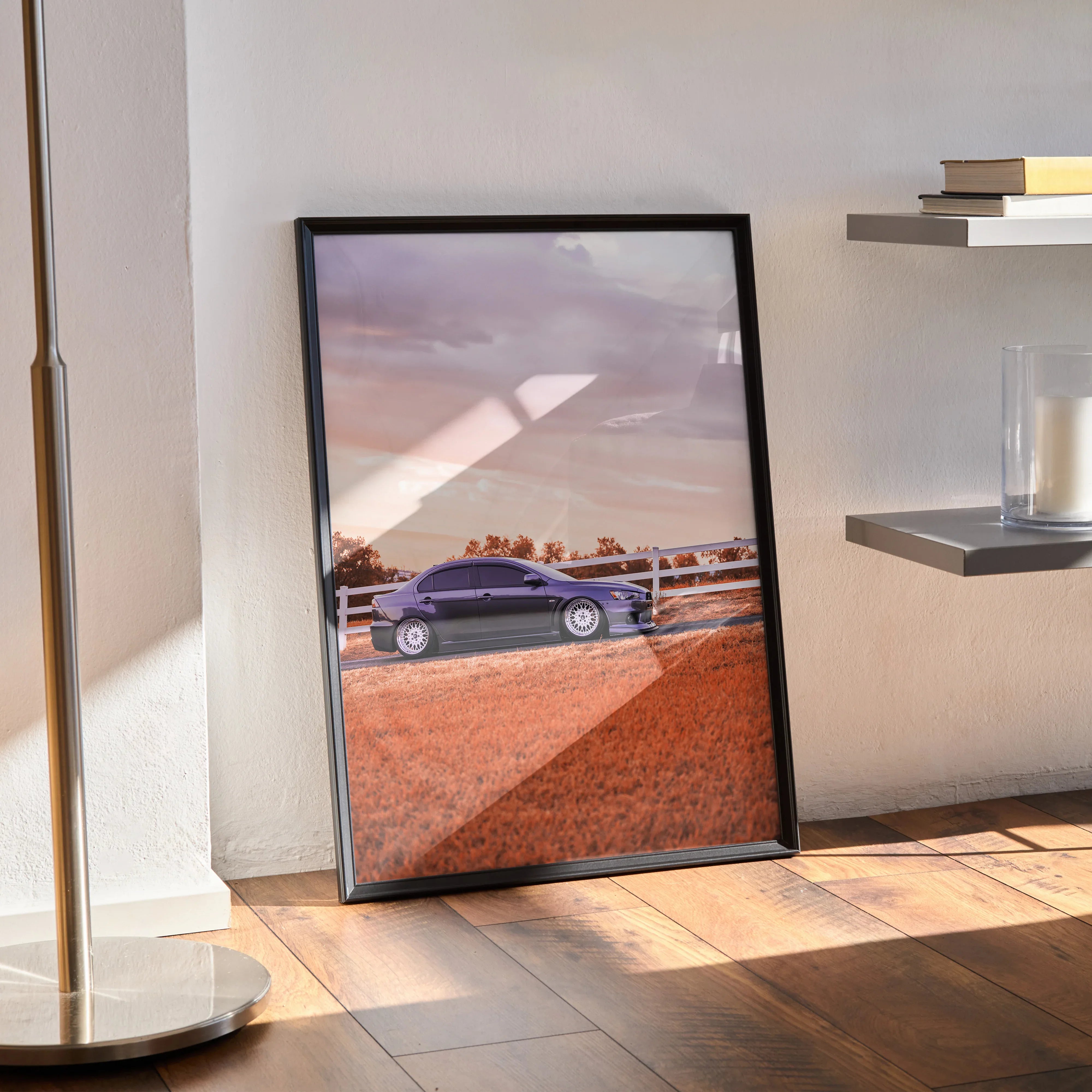 Mitsubishi Evo 10 poster wall art with purple car and sunset sky in black frame standing on wooden floor.