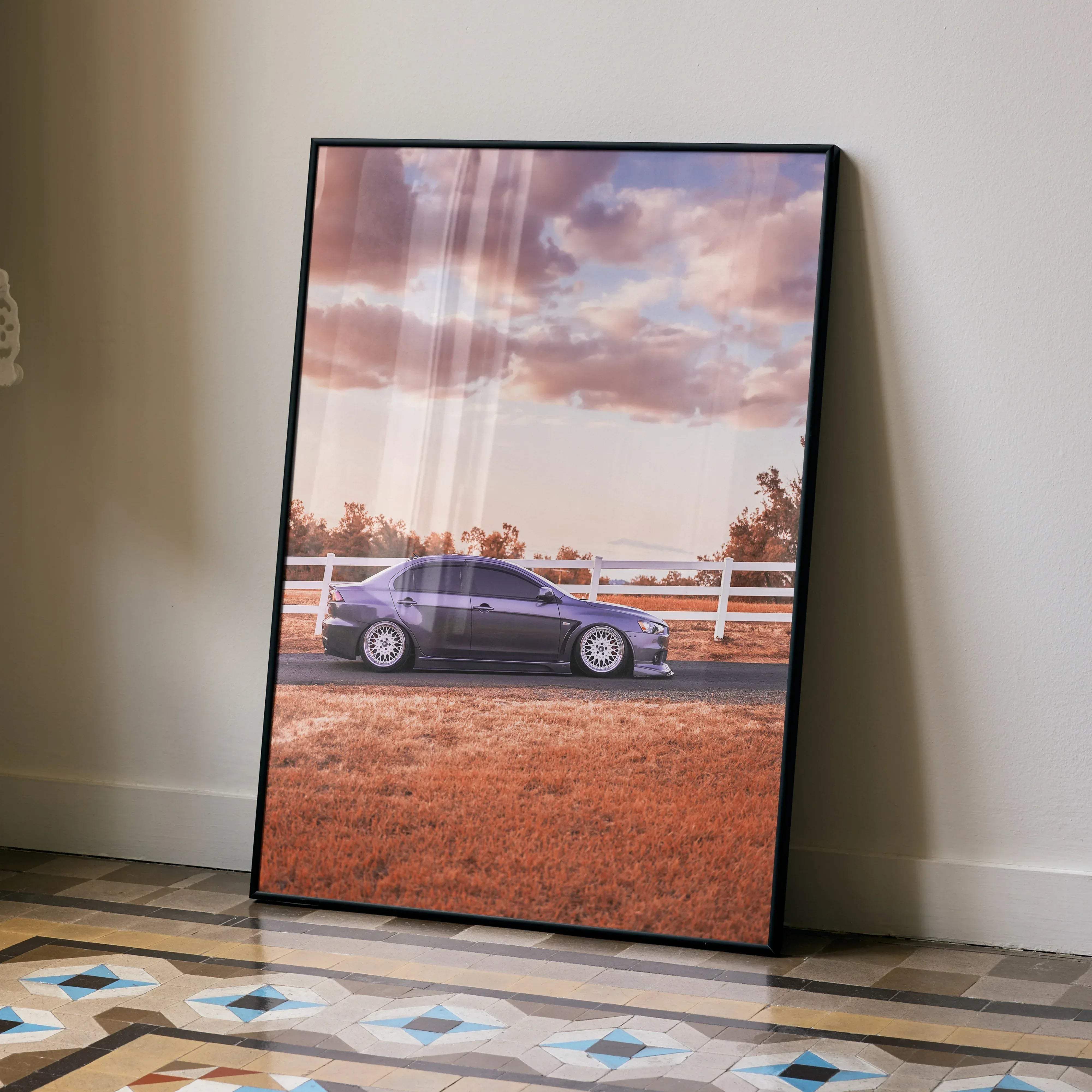 A framed Mitsubishi Evo 10 high resolution poster featuring a purple sports car beside a white fence under cloudy sky