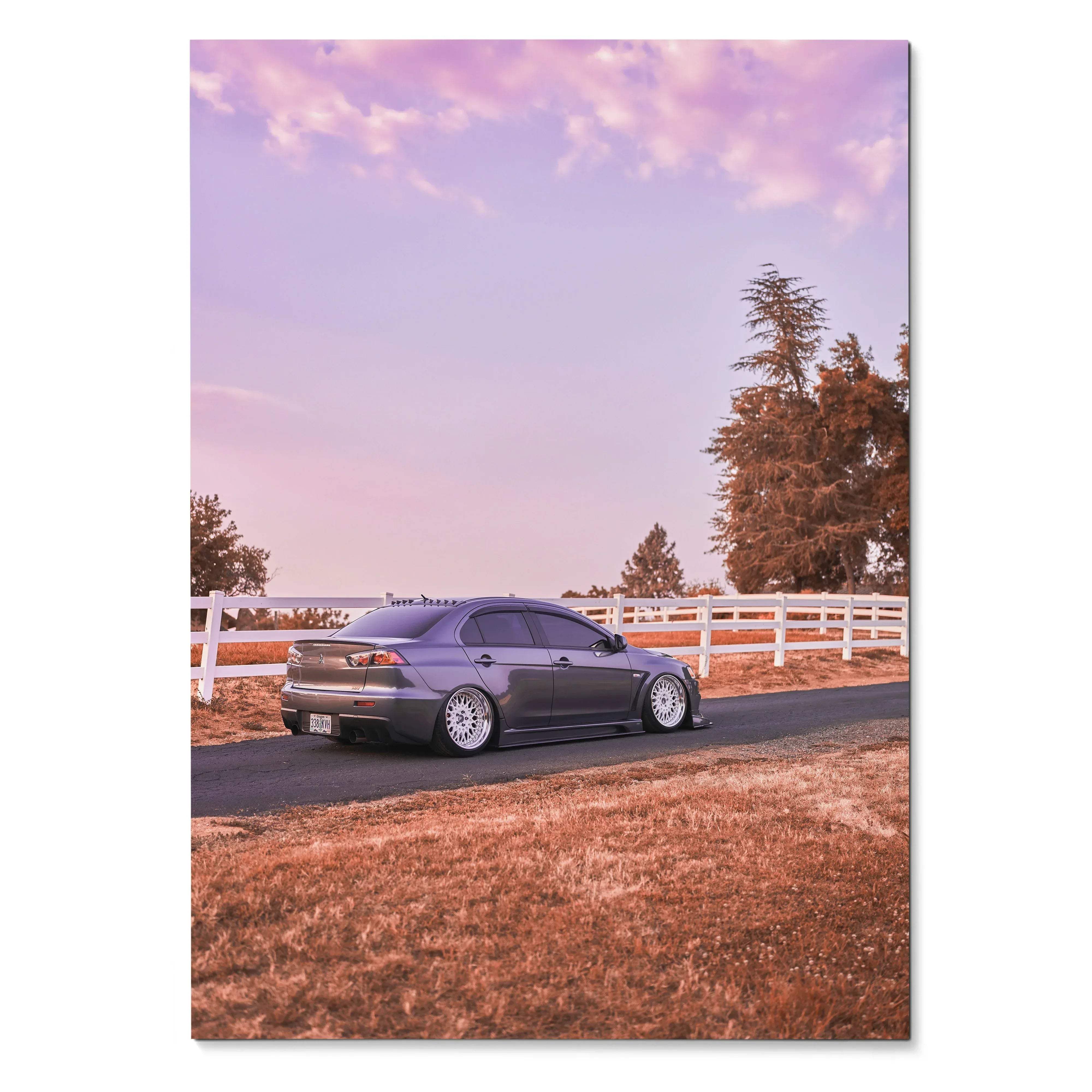 Mitsubishi Evo 10 sports car parked by white fence under pink sky wall art poster.