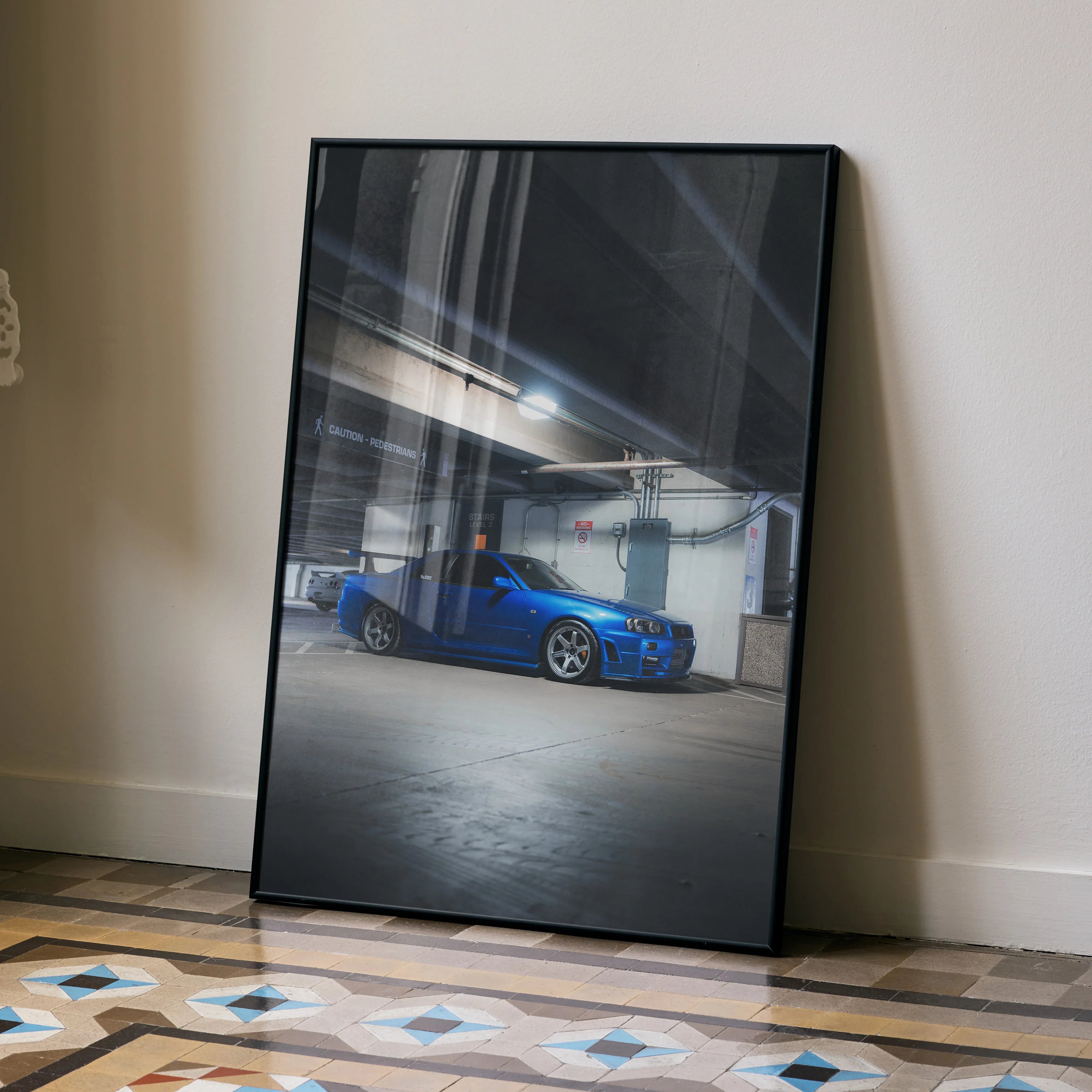 Nissan R34 GTR Skyline blue sports car poster leaning on wall, modern garage scene wall art.