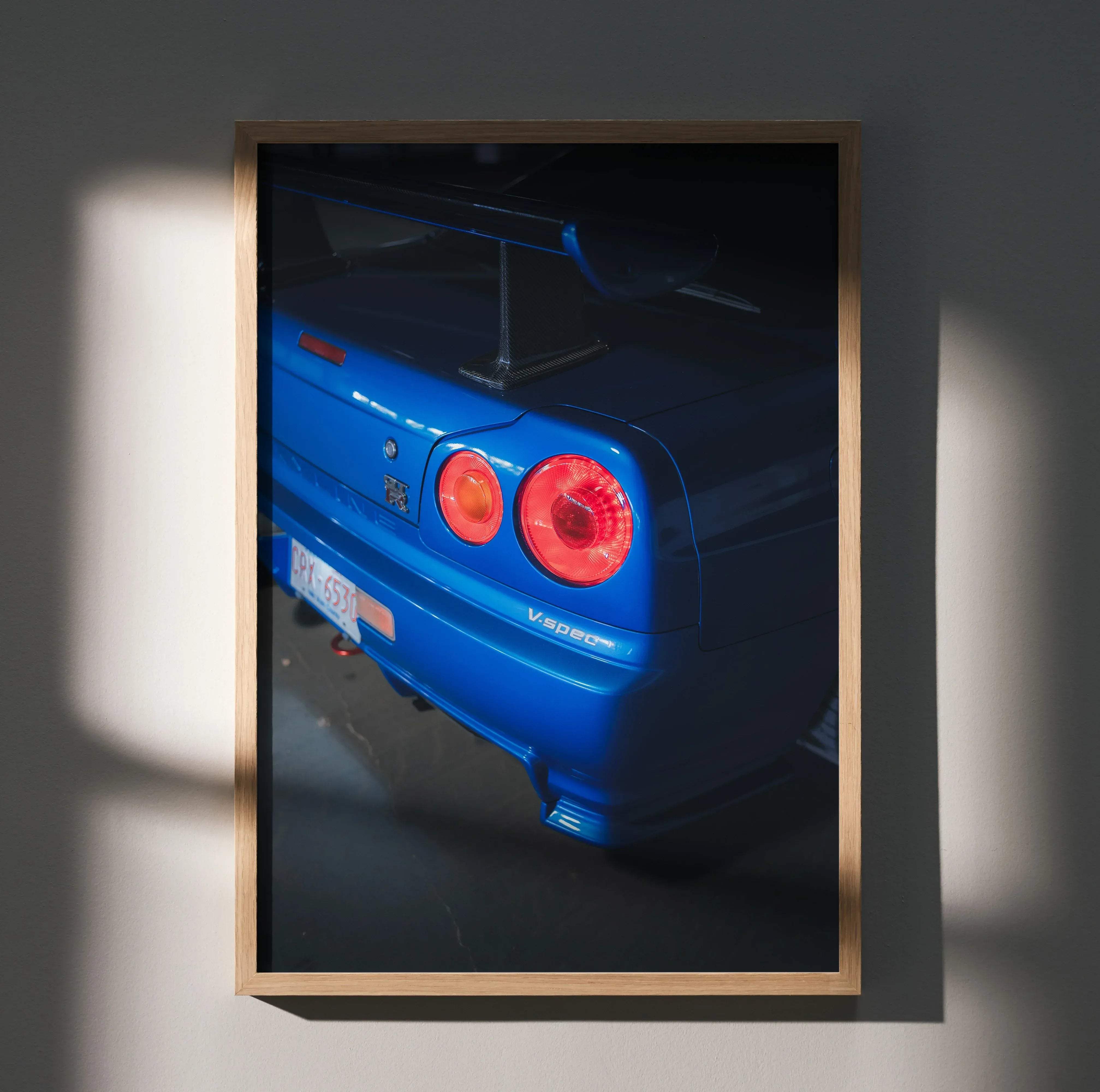 Rear view of blue nissan gt-r v-spec in a light wood frame for nissan r34 gtr skyline high resolution car poster 033