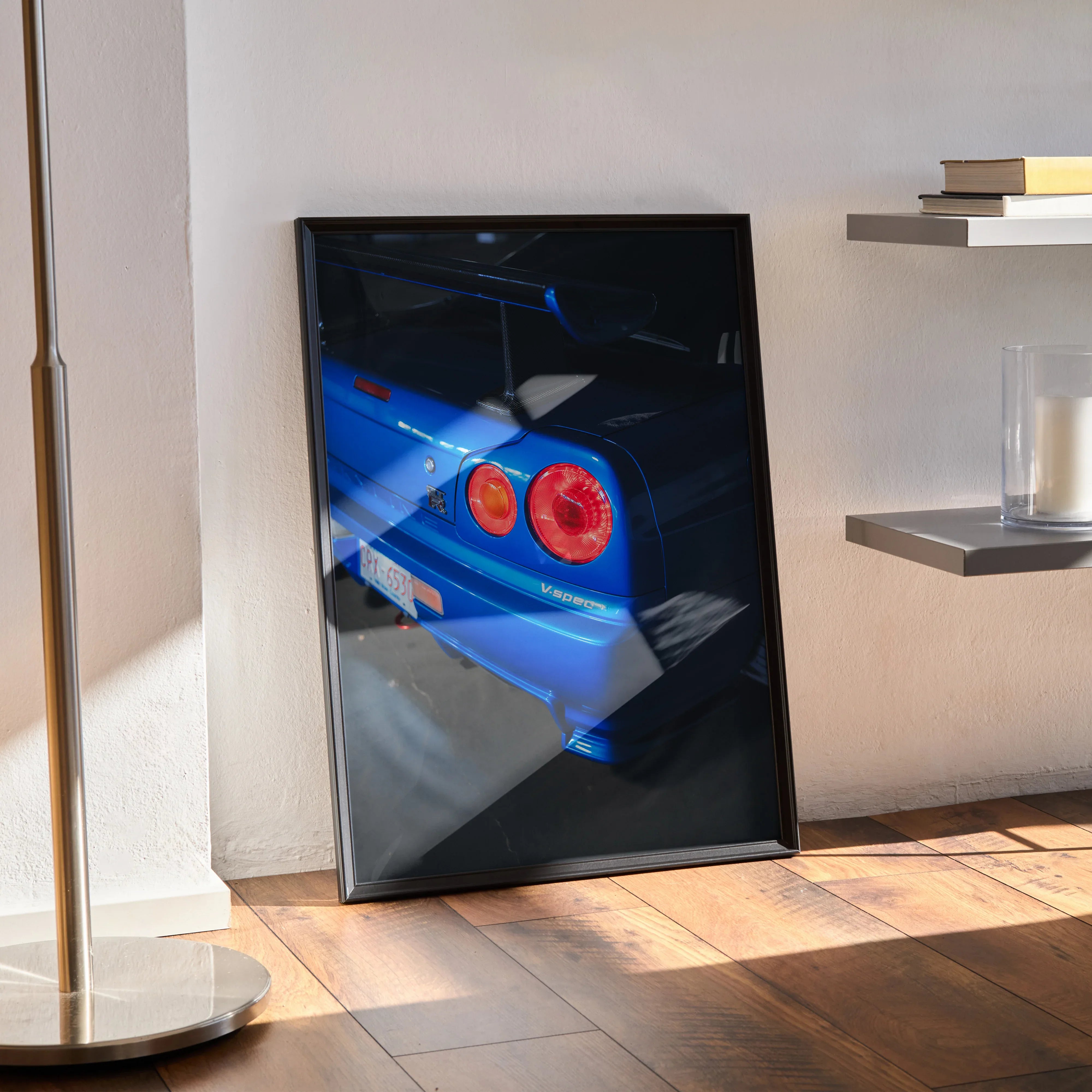 Nissan R34 GTR Skyline blue rear close-up poster wall art in black frame leaning on floor.