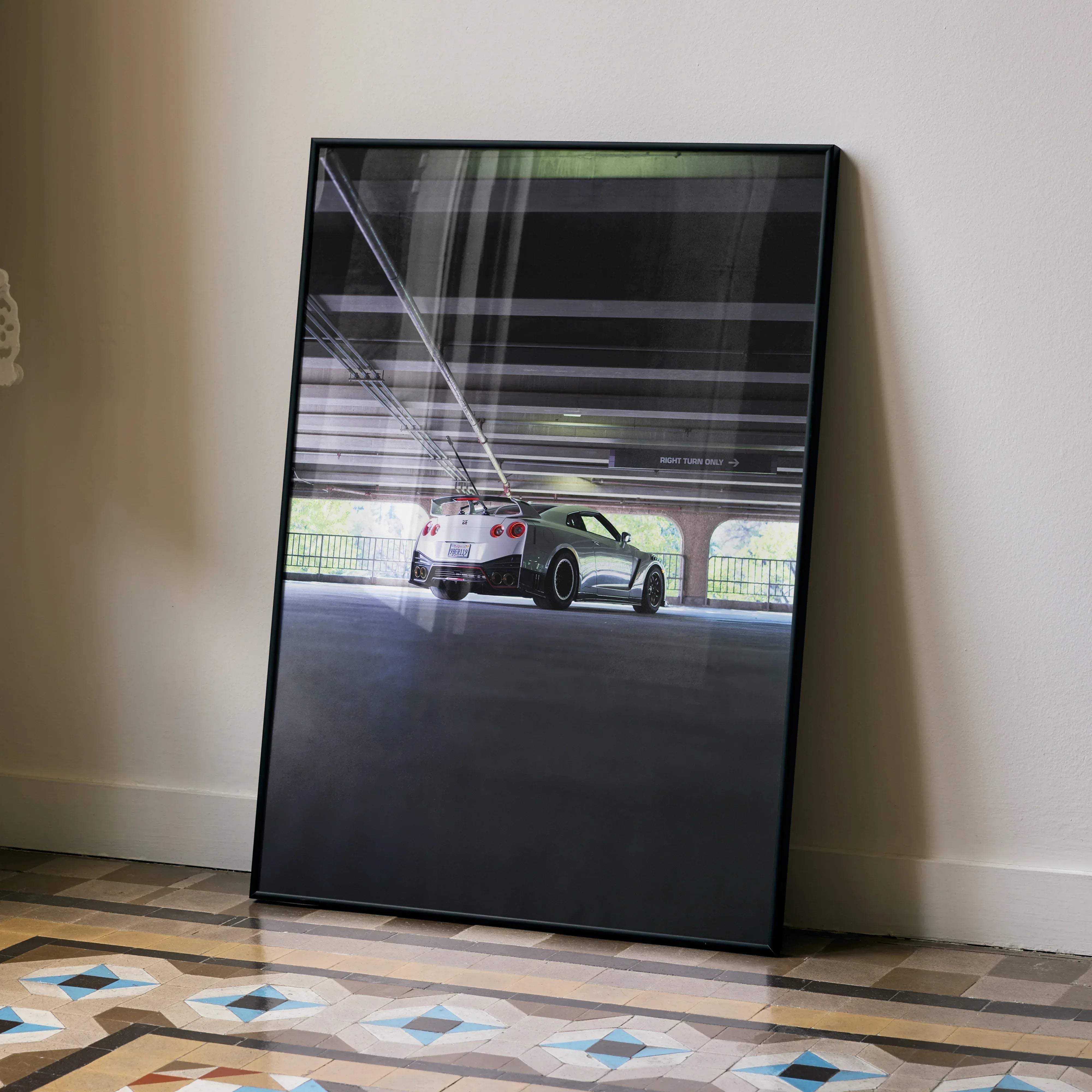 Black-framed poster featuring a white and green Nissan GT-R R35 sports car parked under an overpass