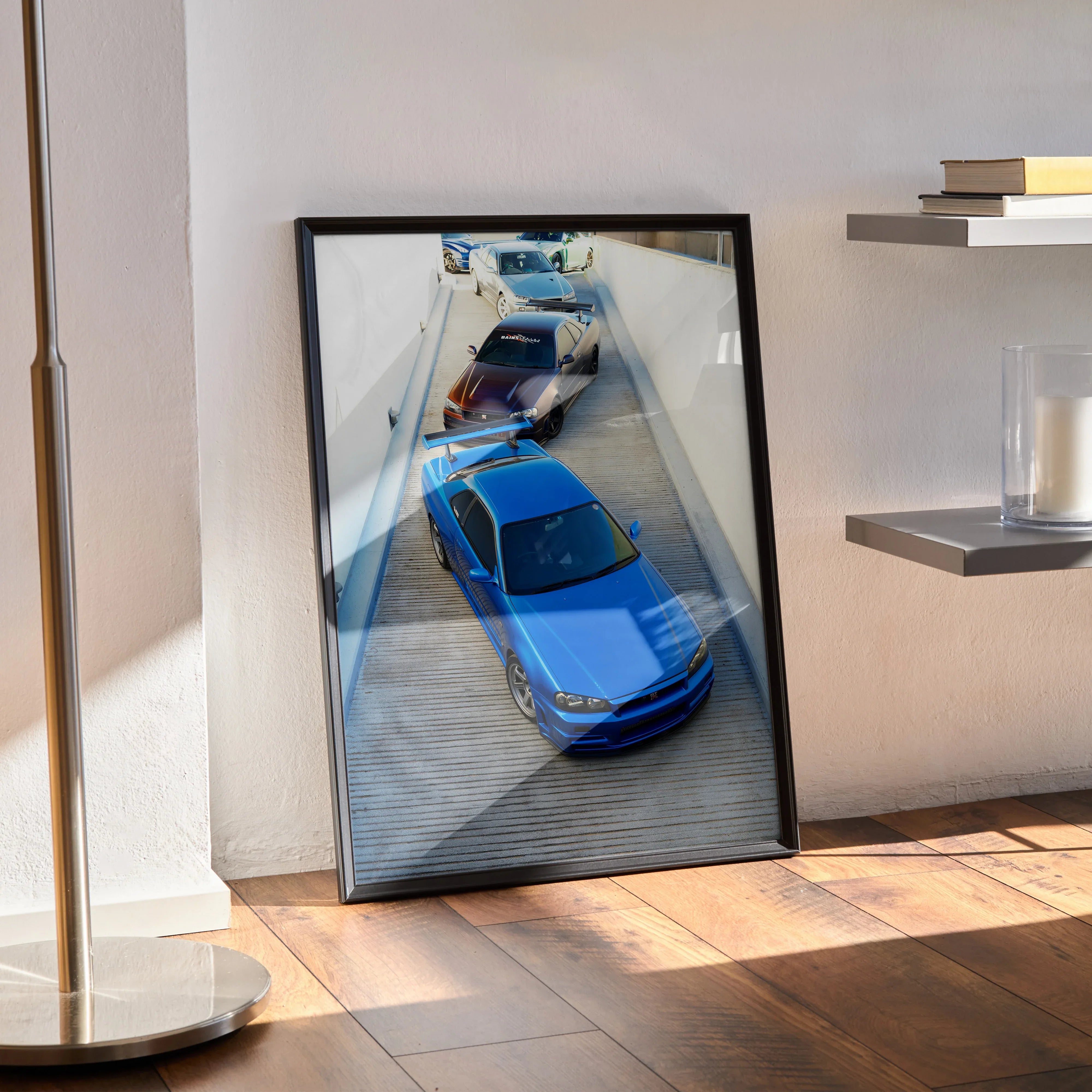 Blue Nissan R34 GTR Skyline poster leaning against wall, modern wall art in black frame.