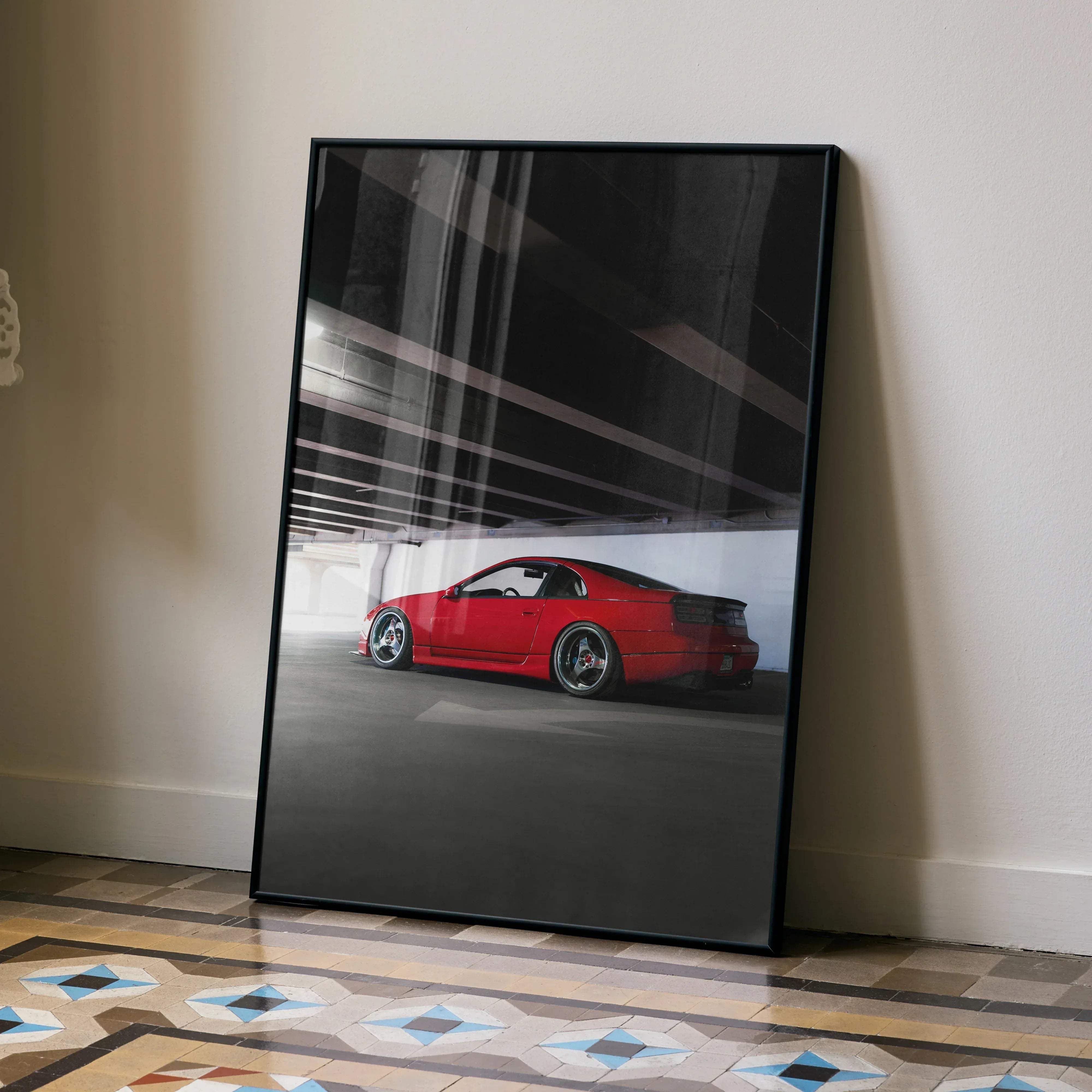 Black-framed poster featuring a vibrant red nissan 300zx sports car in a monochrome parking garage setting