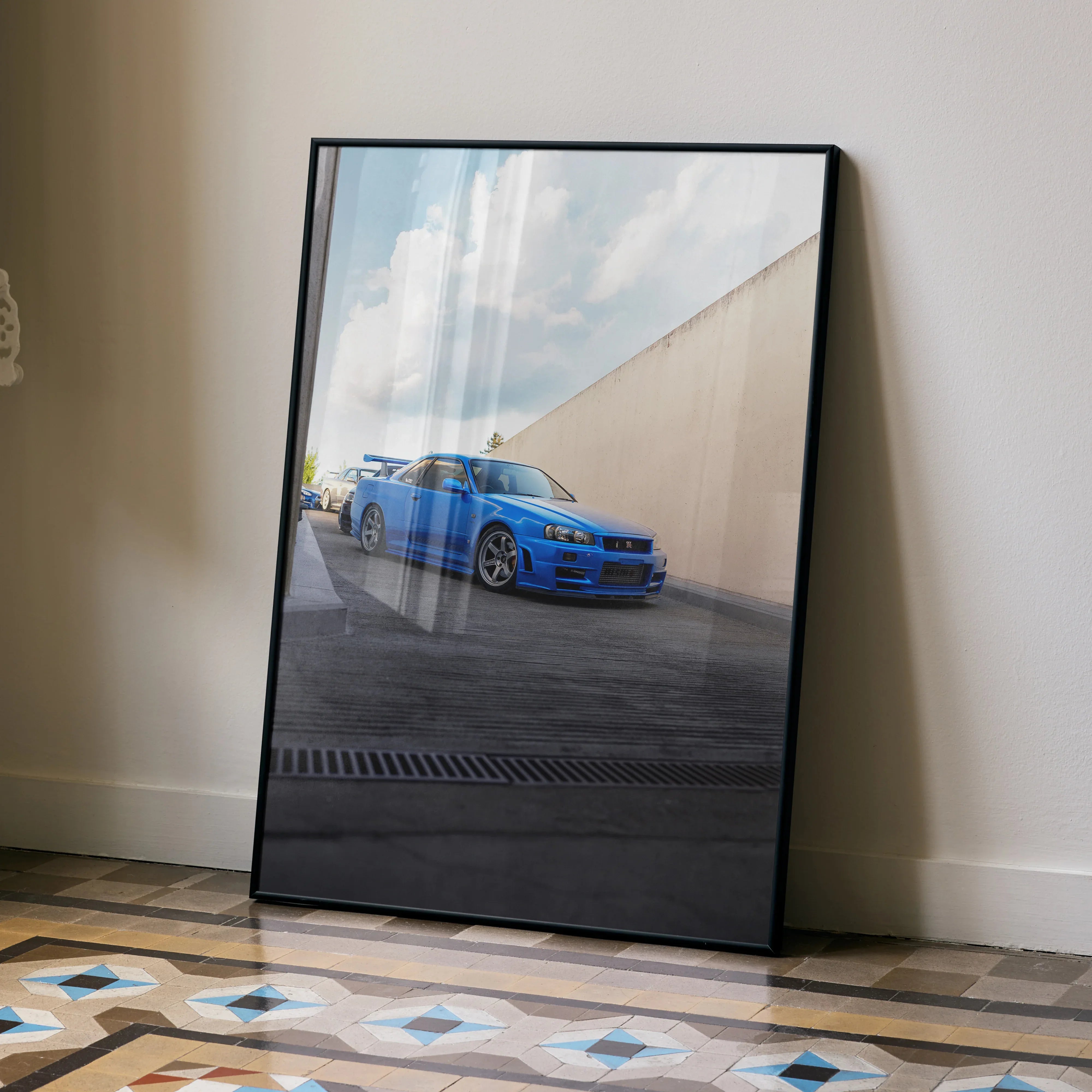Nissan R34 GTR Skyline blue car poster leaning against wall on tiled floor wall art.