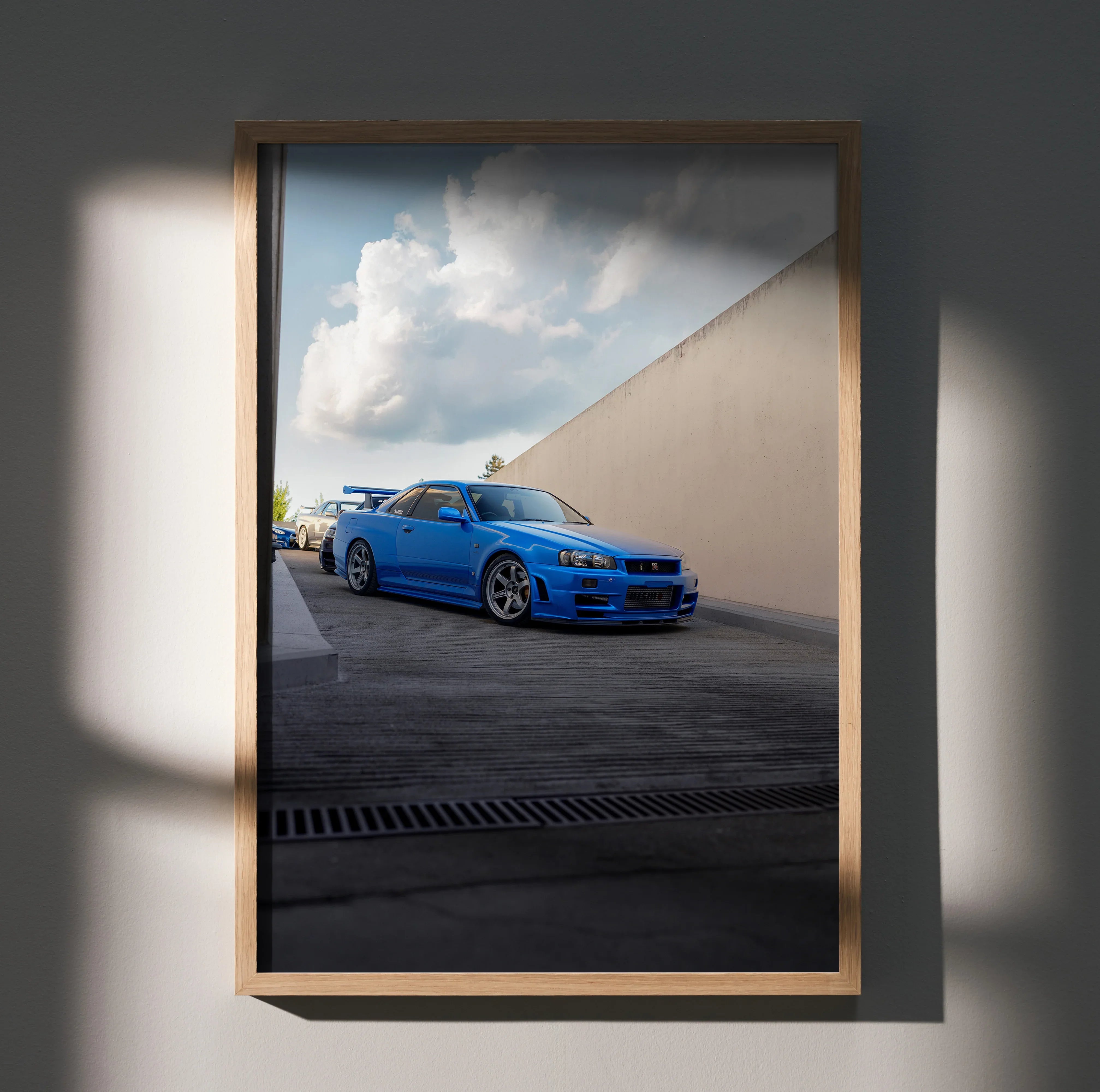 Nissan R34 GTR Skyline in bright blue parked under a cloudy sky poster wall art.