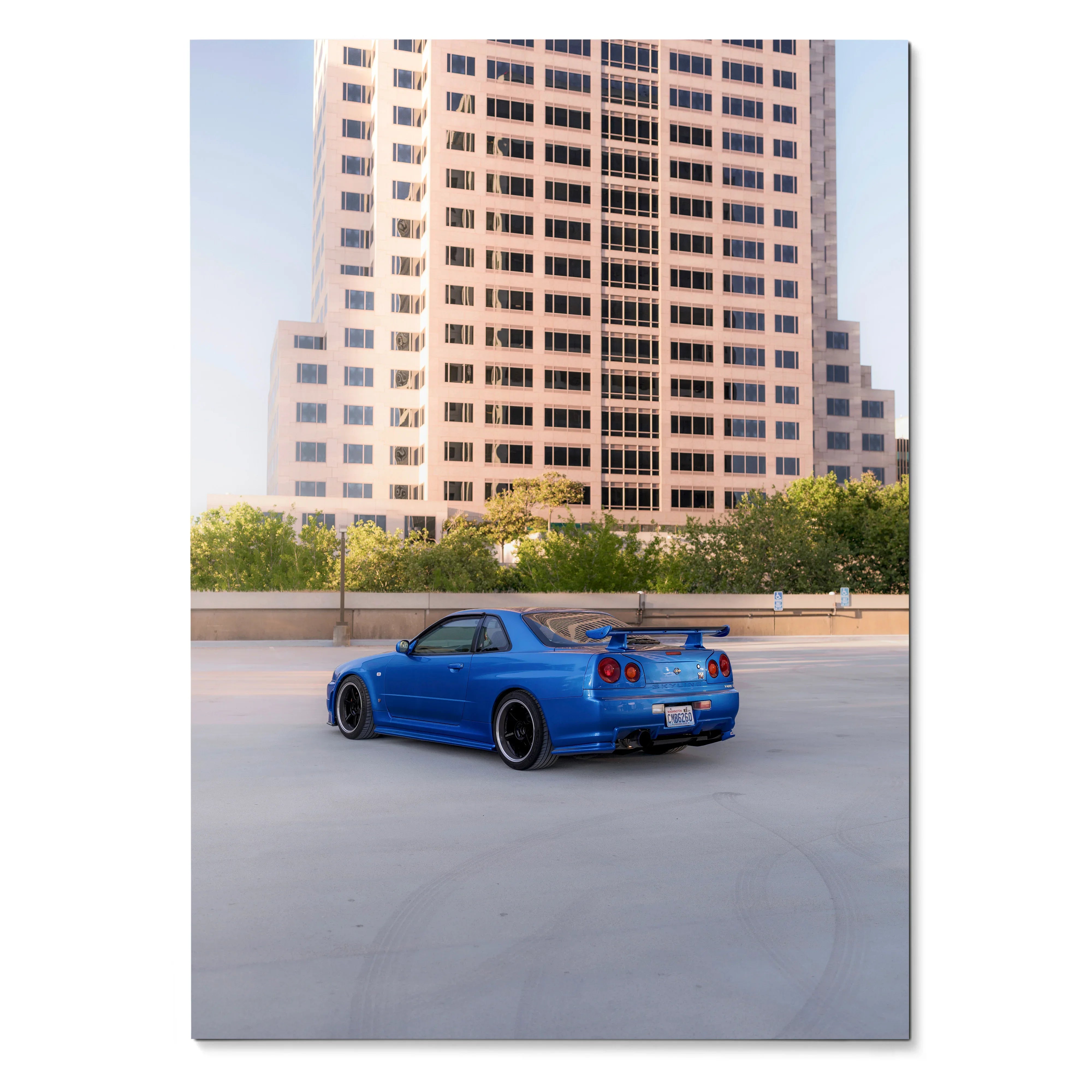 Blue Nissan R34 GTR Skyline parked on rooftop with city building background poster wall art.