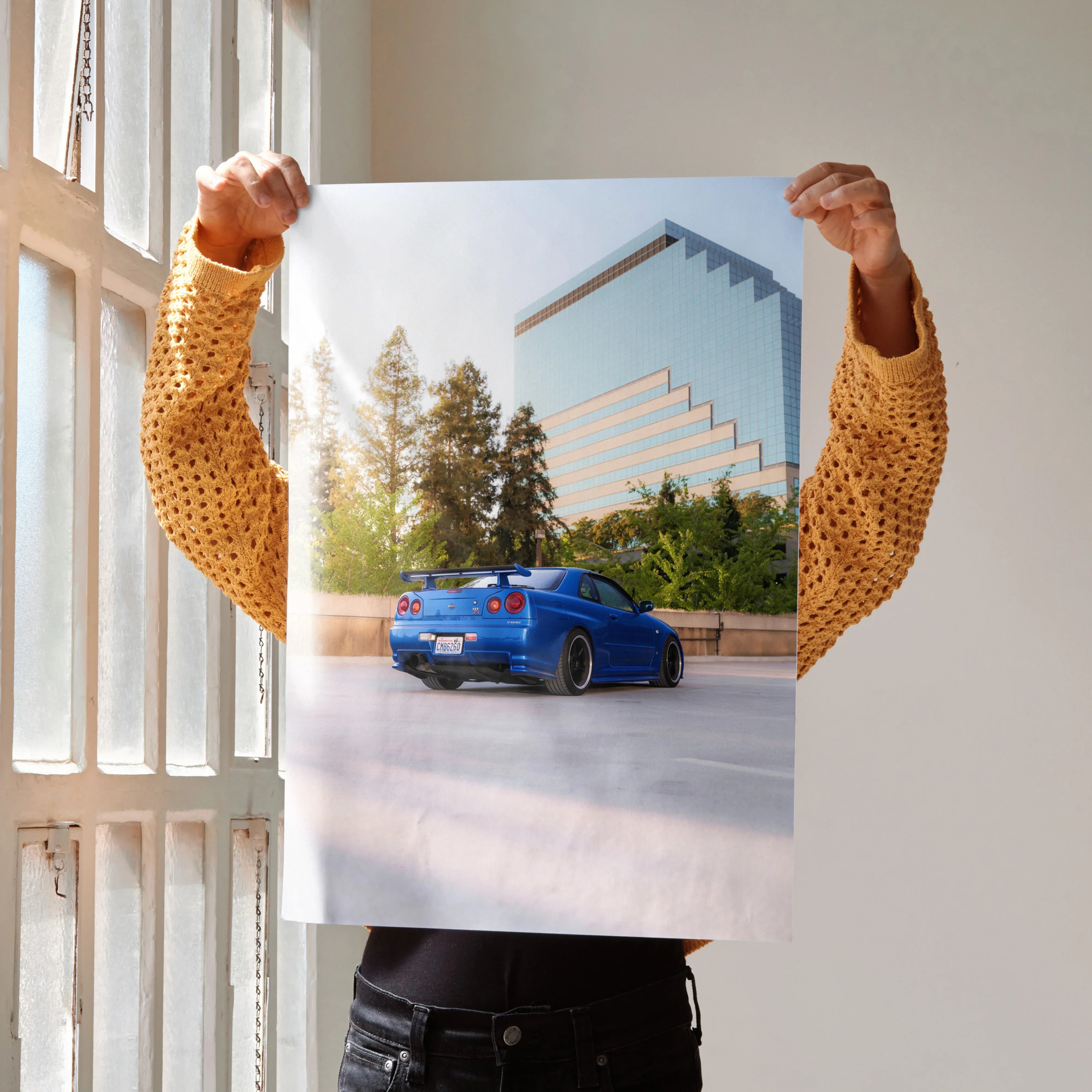 Nissan R34 GTR Skyline blue sports car poster with modern building backdrop wall art.