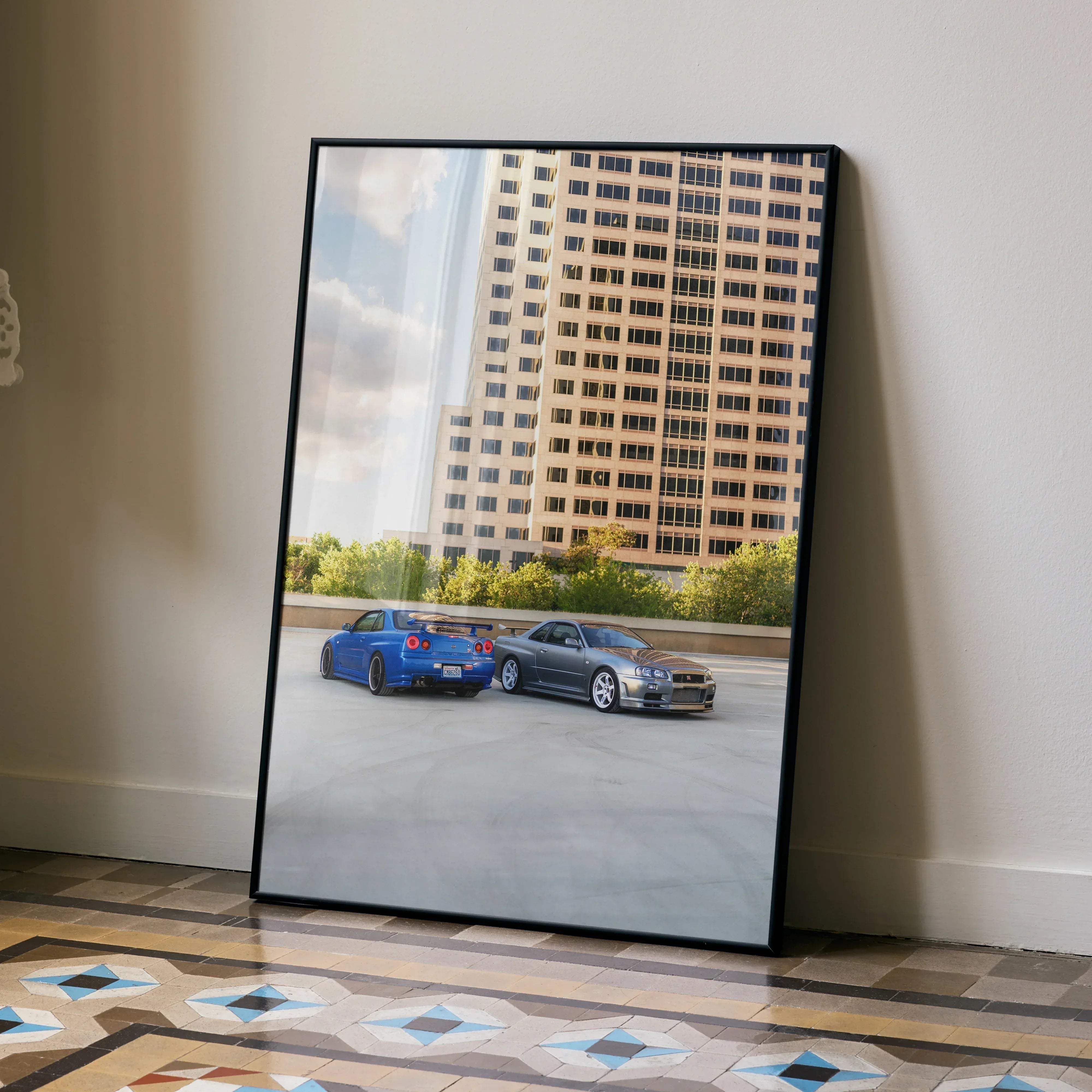 Black-framed poster featuring vibrant blue and gray nissan skyline r34 gtr cars parked on an urban rooftop