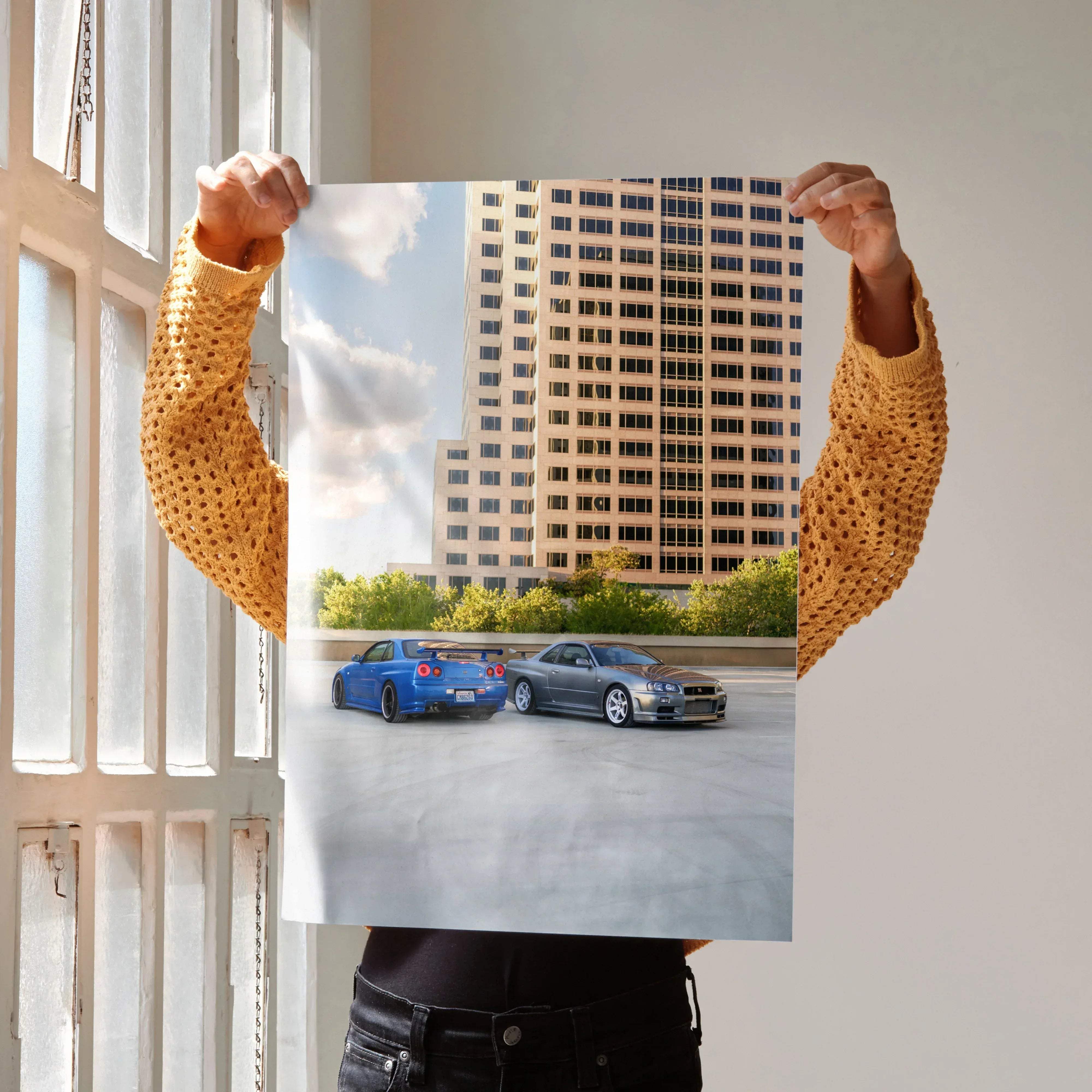 A vibrant blue and metallic gray nissan r34 gtr skyline sports car poster featuring two high-performance models on a rooftop