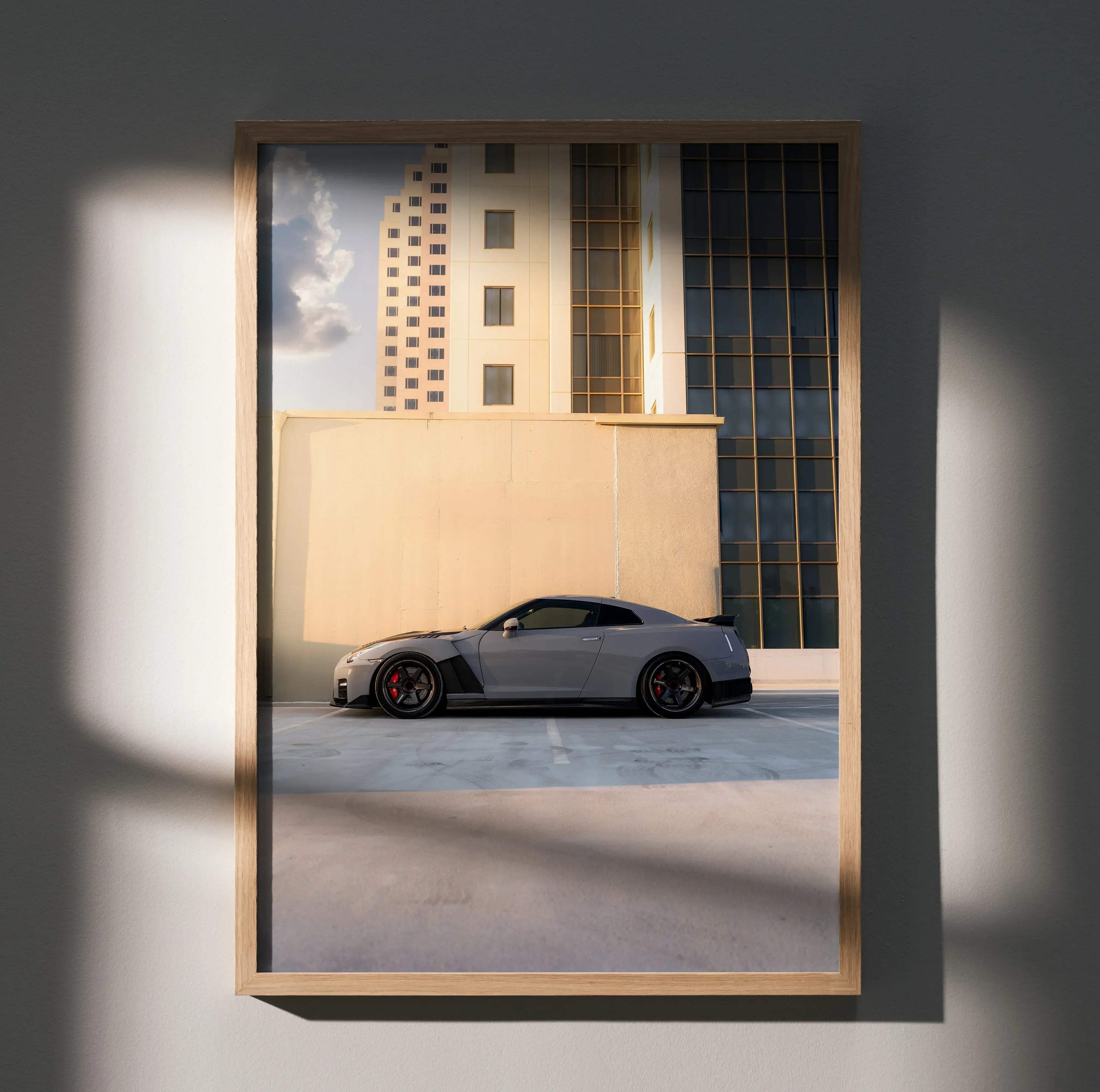 Gray Nissan GT-R R35 sports car with black accents and red brake calipers framed in light wood high resolution poster