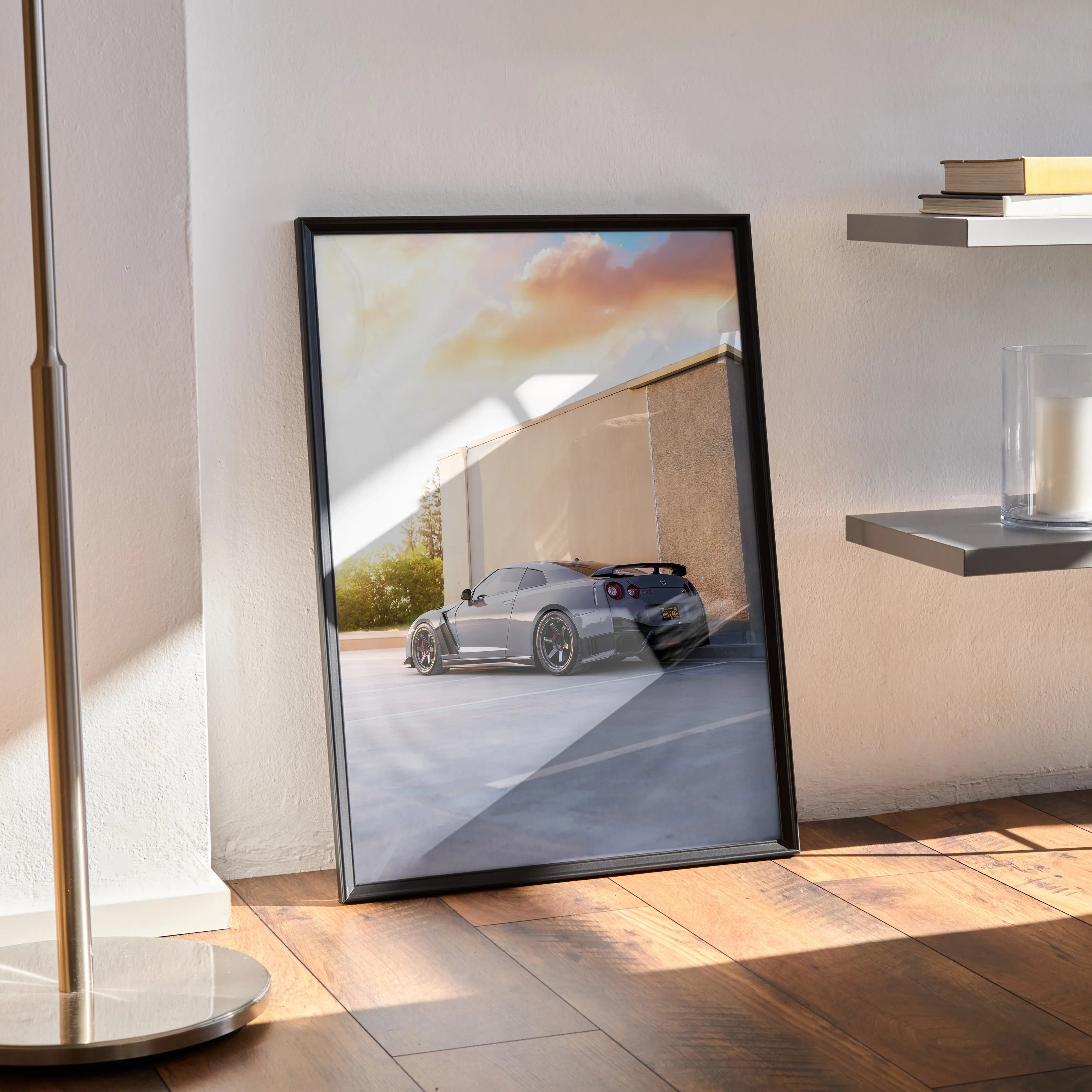 Nissan GTR R35 poster with sunset background in black frame leaning on floor wall art.