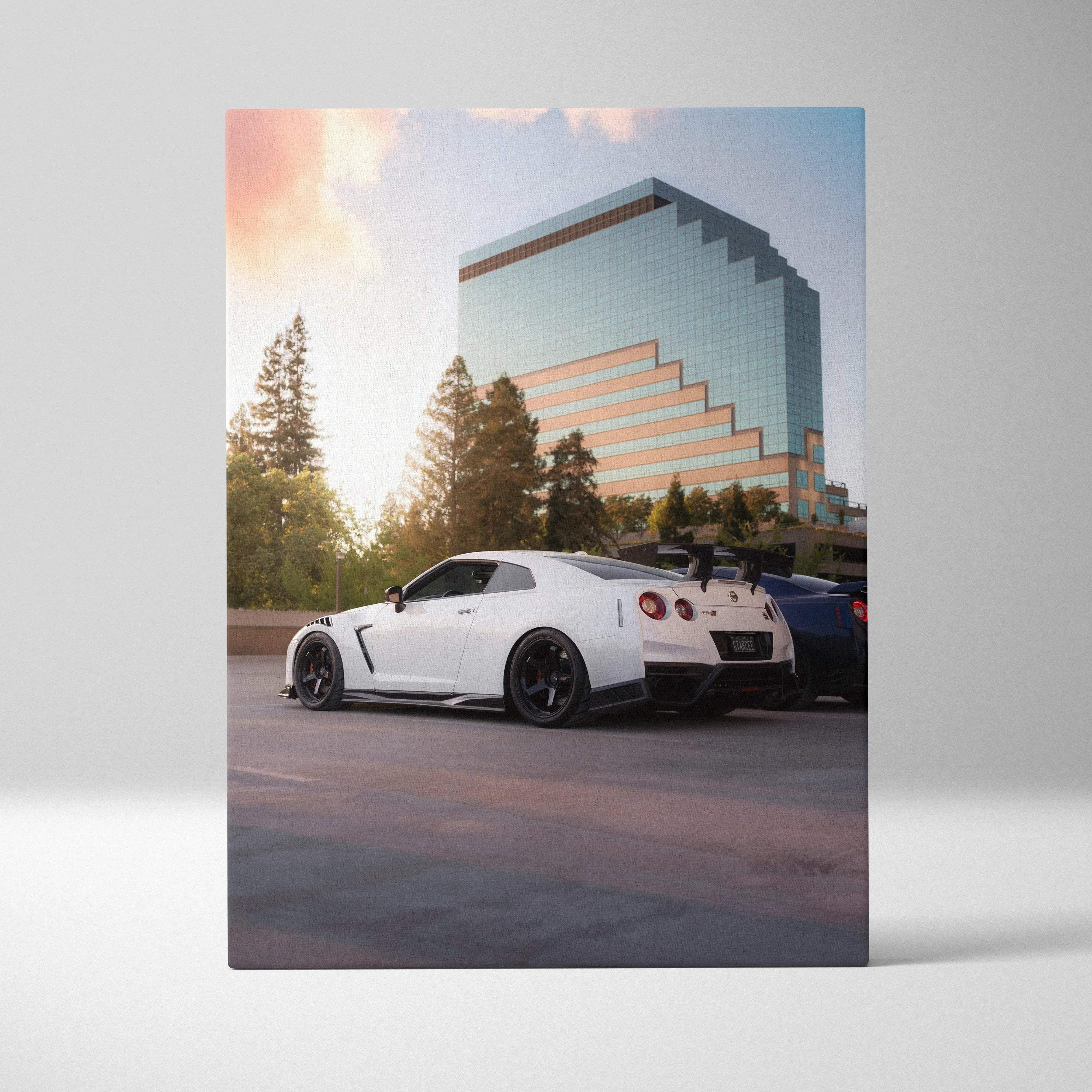 Canvas wall art automotive nissan gtr r35 white with black rims and rear spoiler parked by modern glass building vertical print