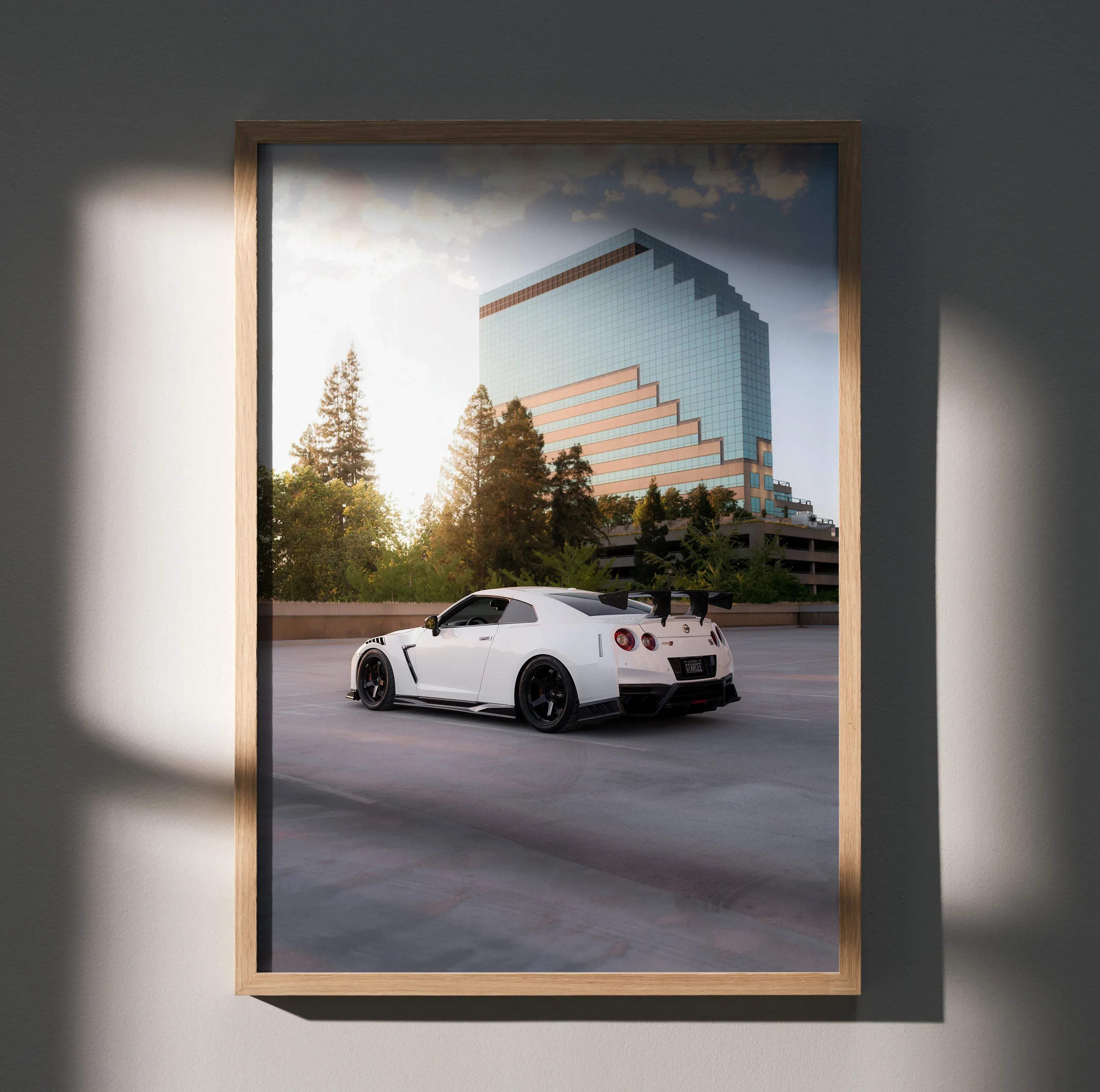 White nissan gt-r r35 sports car with black rims and rear spoiler in a light wood frame high resolution poster
