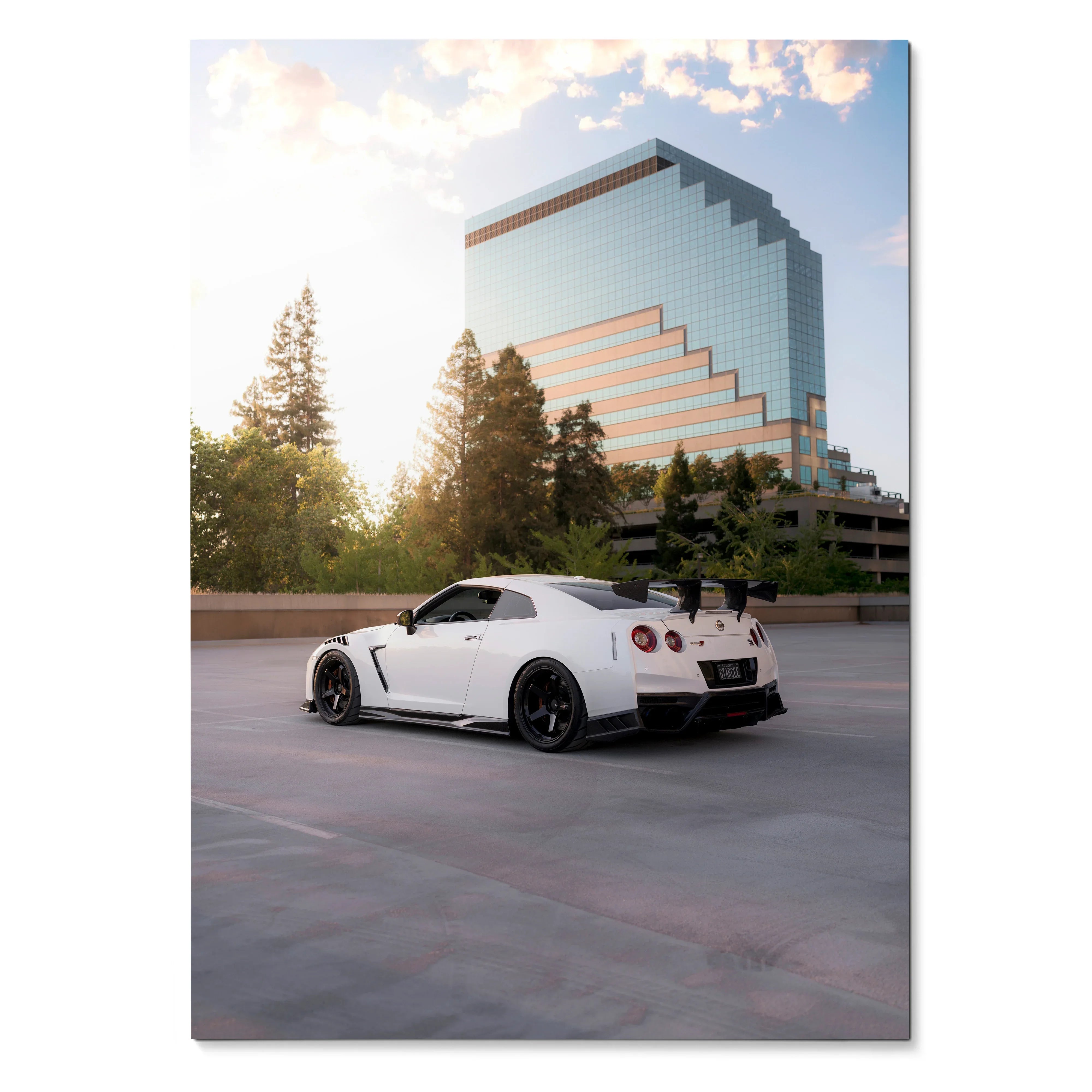 Nissan GTR R35 white sports car parked against modern glass building wall art poster.