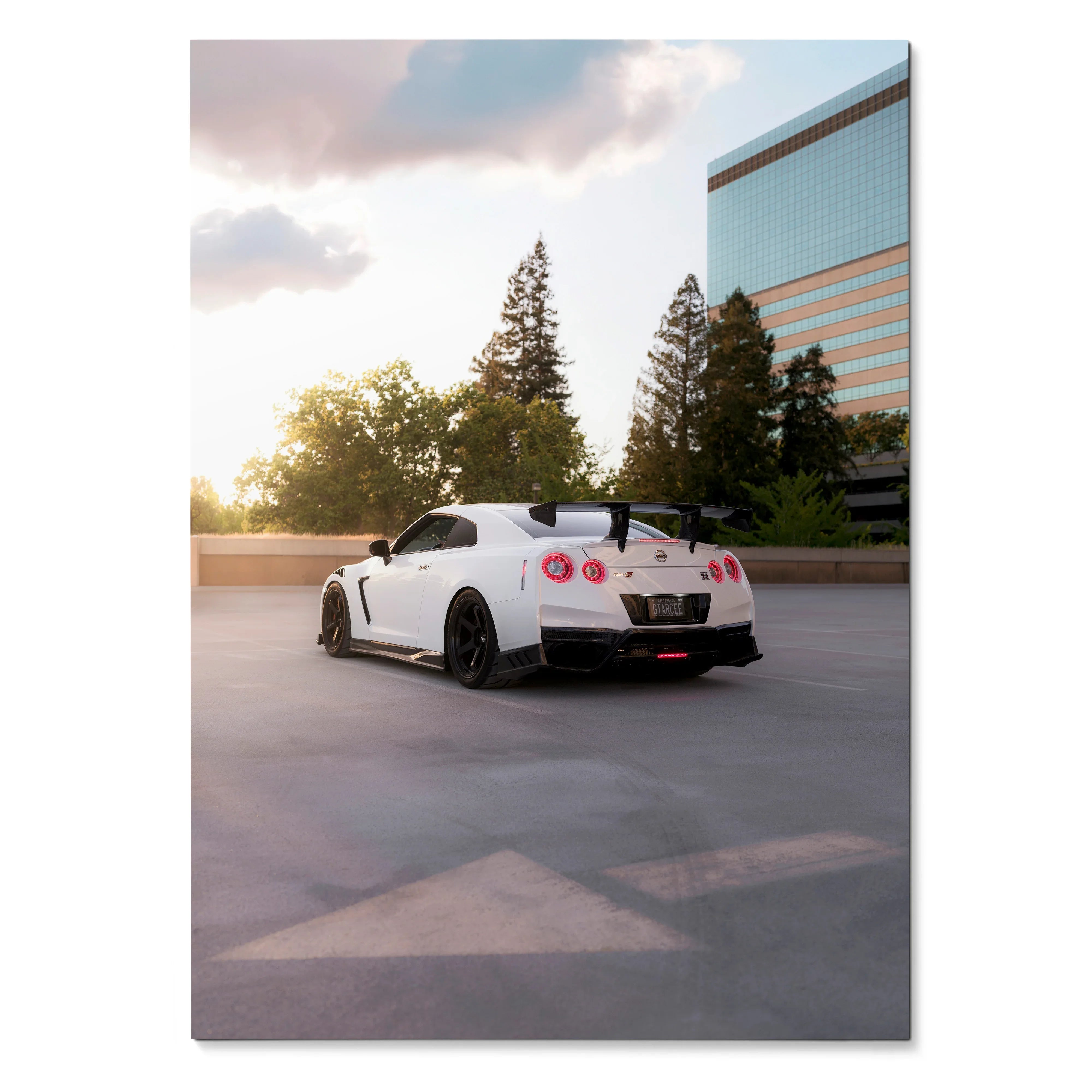 Nissan R35 GTR in white parked at sunset with trees and building reflected, car poster wall art.