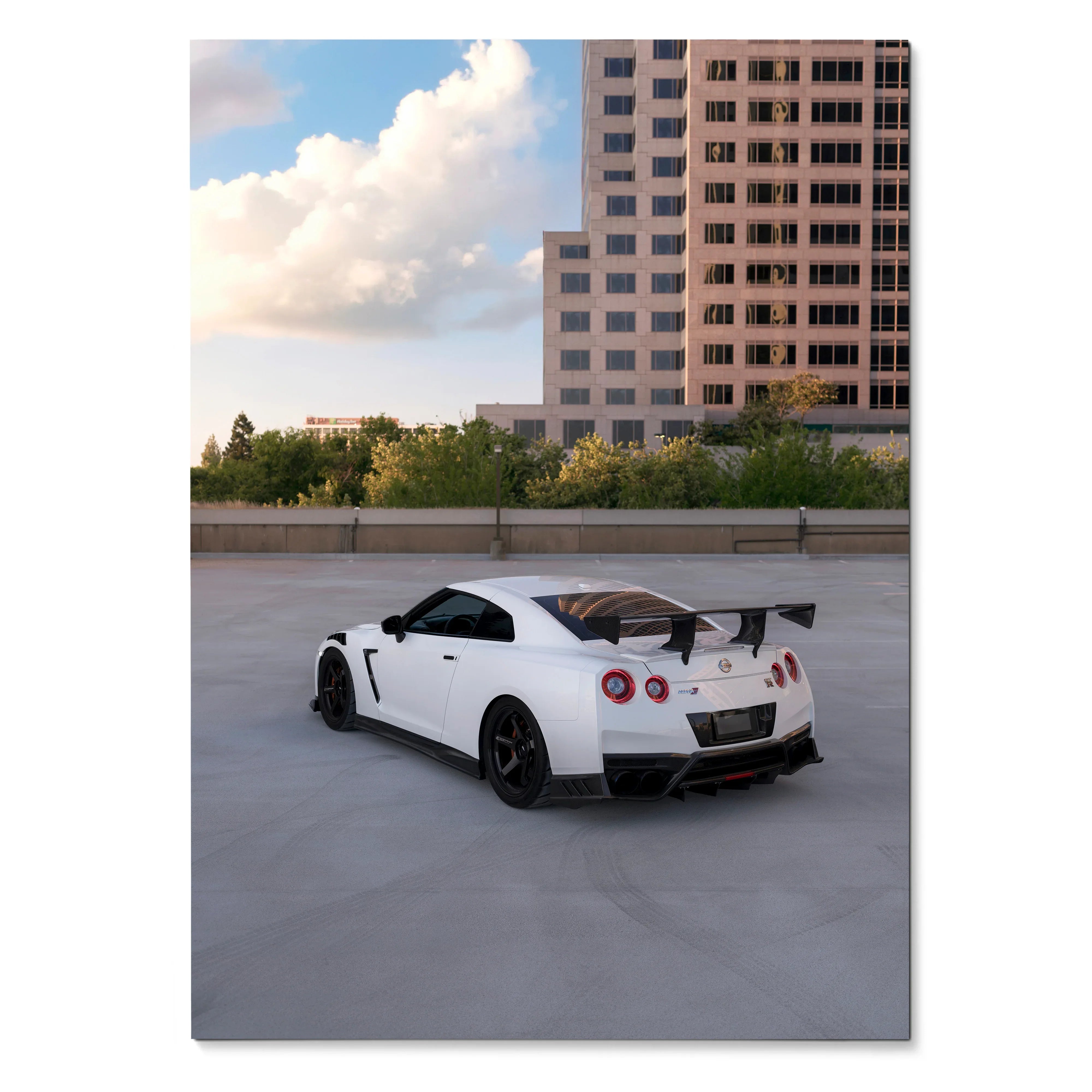 White Nissan GTR R35 with black accents and rear spoiler parked in urban setting poster wall art.