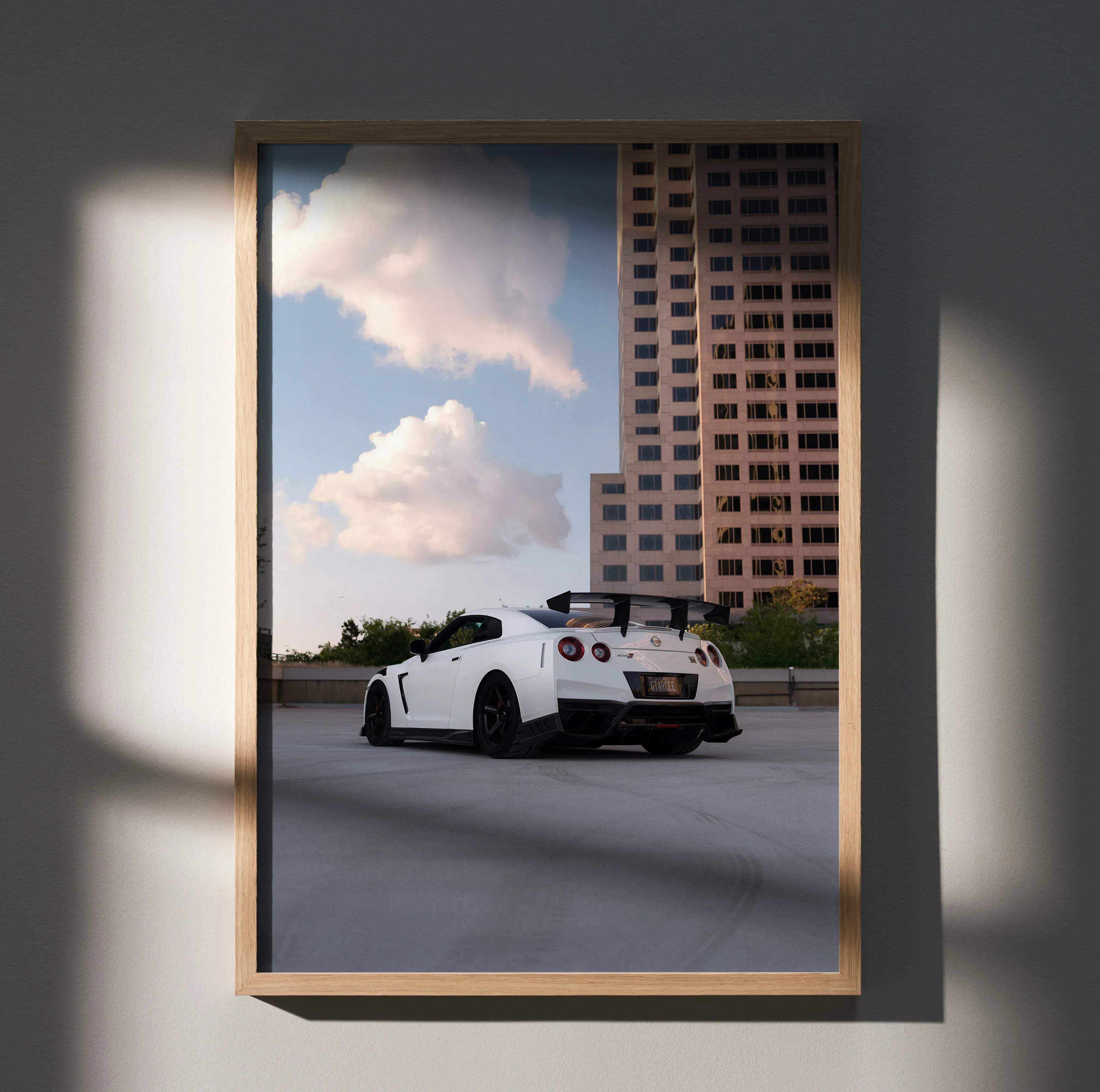 White Nissan GTR R35 sports car poster with black rims and rear spoiler framed in light wood for high resolution display