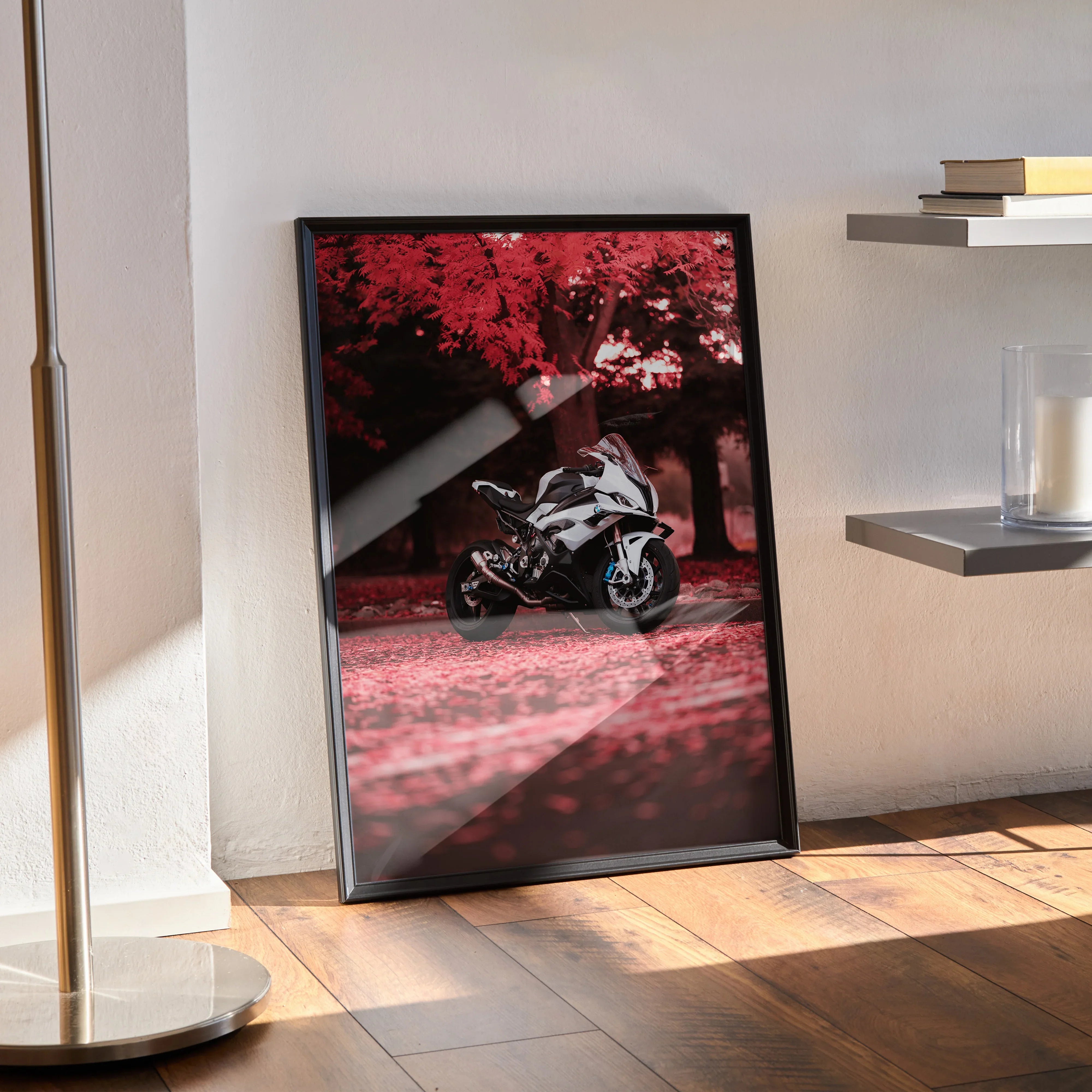BMW S1000RR motorcycle poster with red tree background framed as wall art on floor.