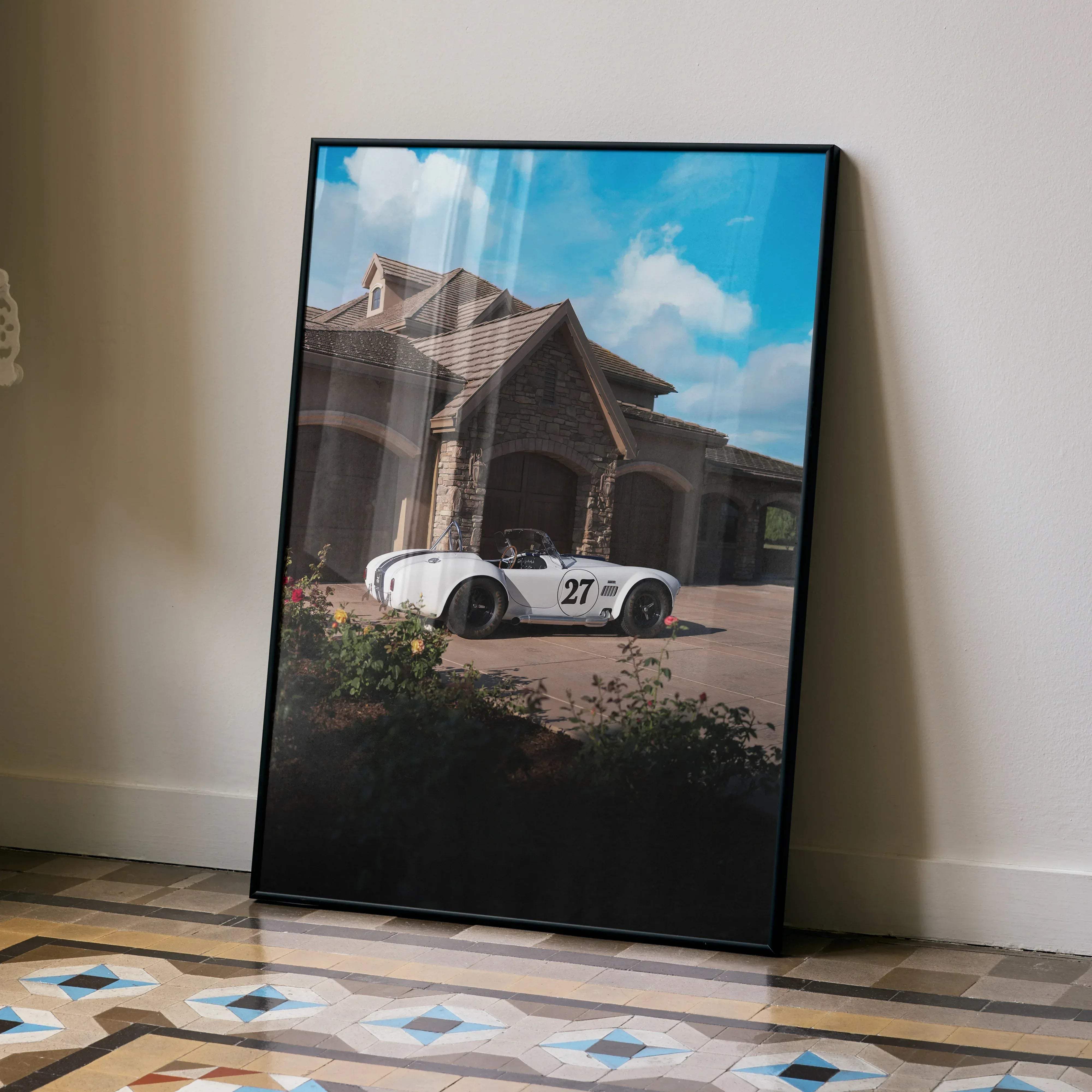 Black-framed shelby cobra high resolution car poster featuring a white vintage race car number 27 by a stone house