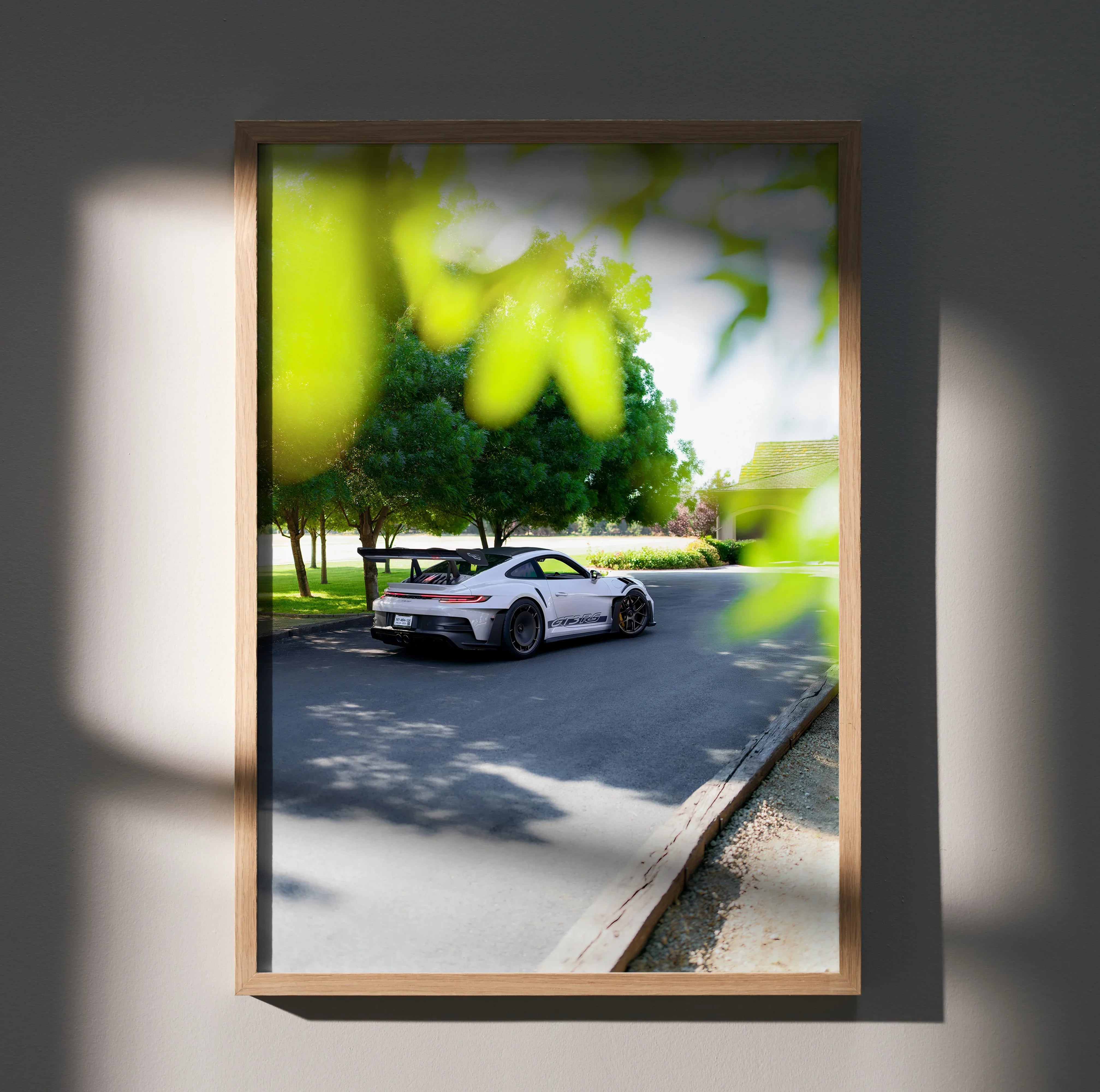 Porsche 911 GT3 RS poster showing white sports car on a sunny suburban road, wall art in natural wooden frame.